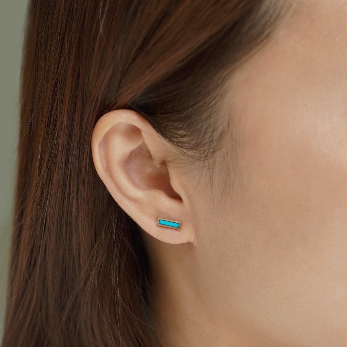 14K gold turquoise inlay bar stud, shown on a model's earlobe