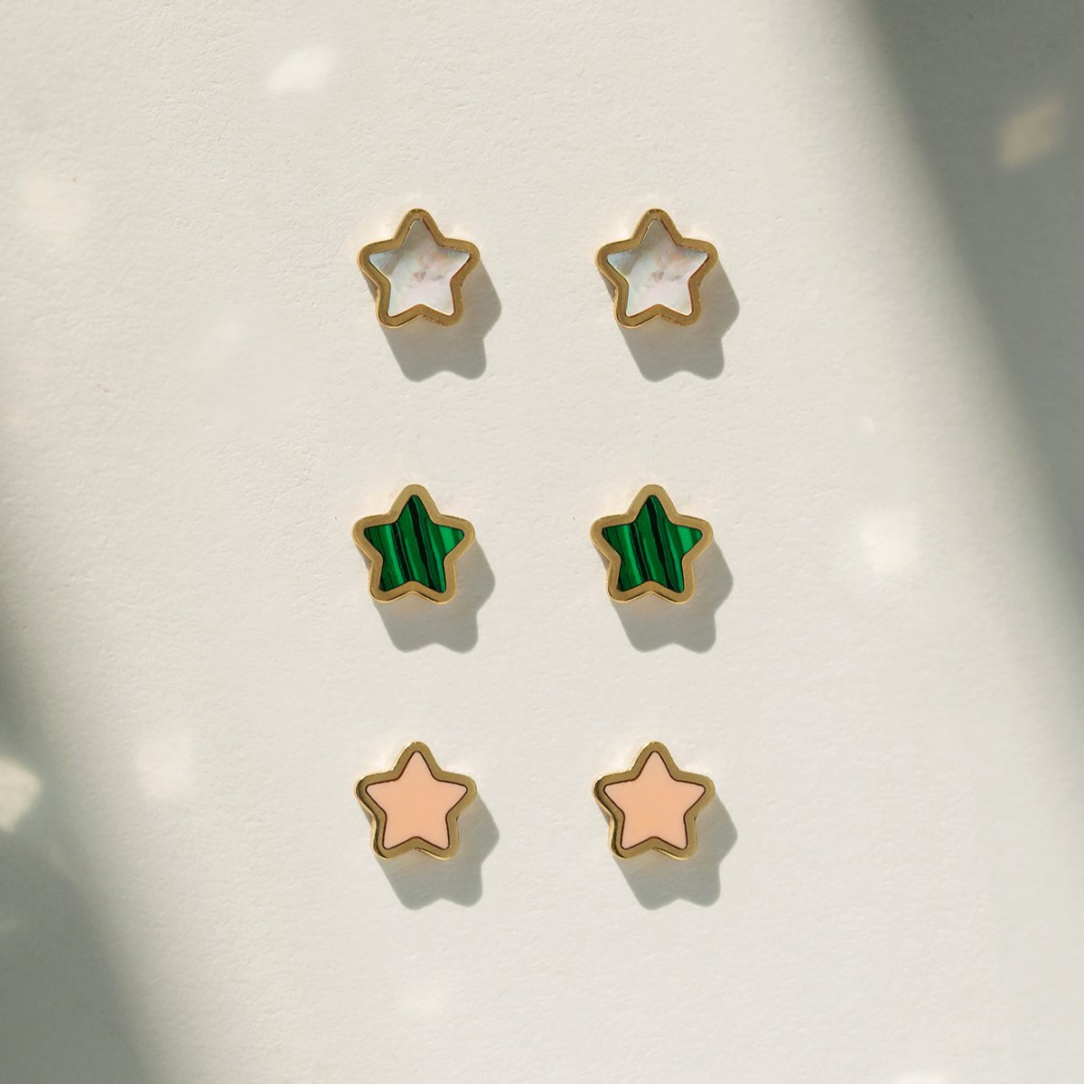 14K gold rose quartz star stud shown on a model's earlobe