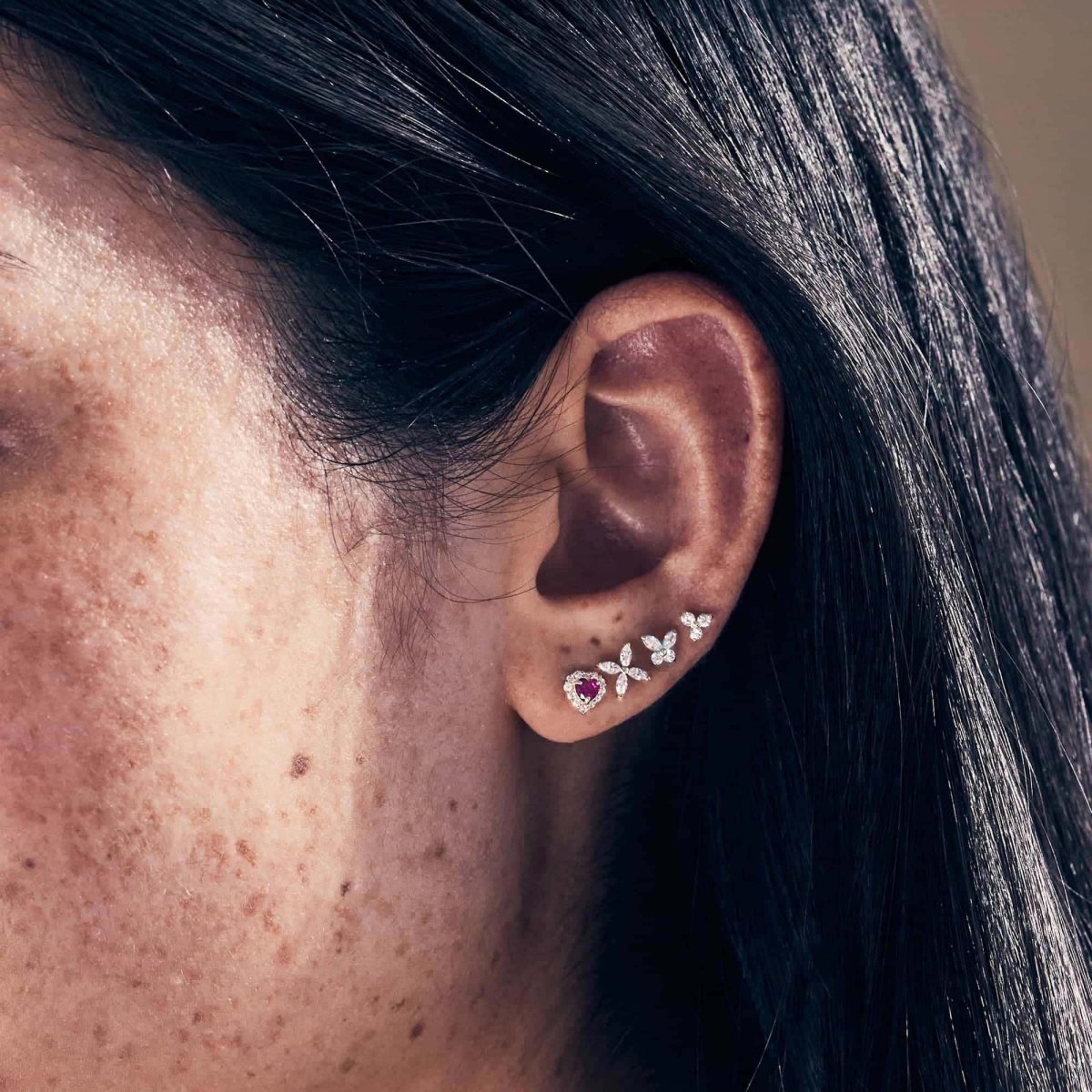 14K white gold crystal butterfly studs styled in a lobe stack, shown on a model