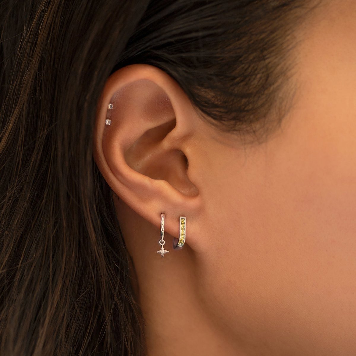 14K gold citrine huggie hoop with yellow stones, shown on a model's lobe in an ear stack