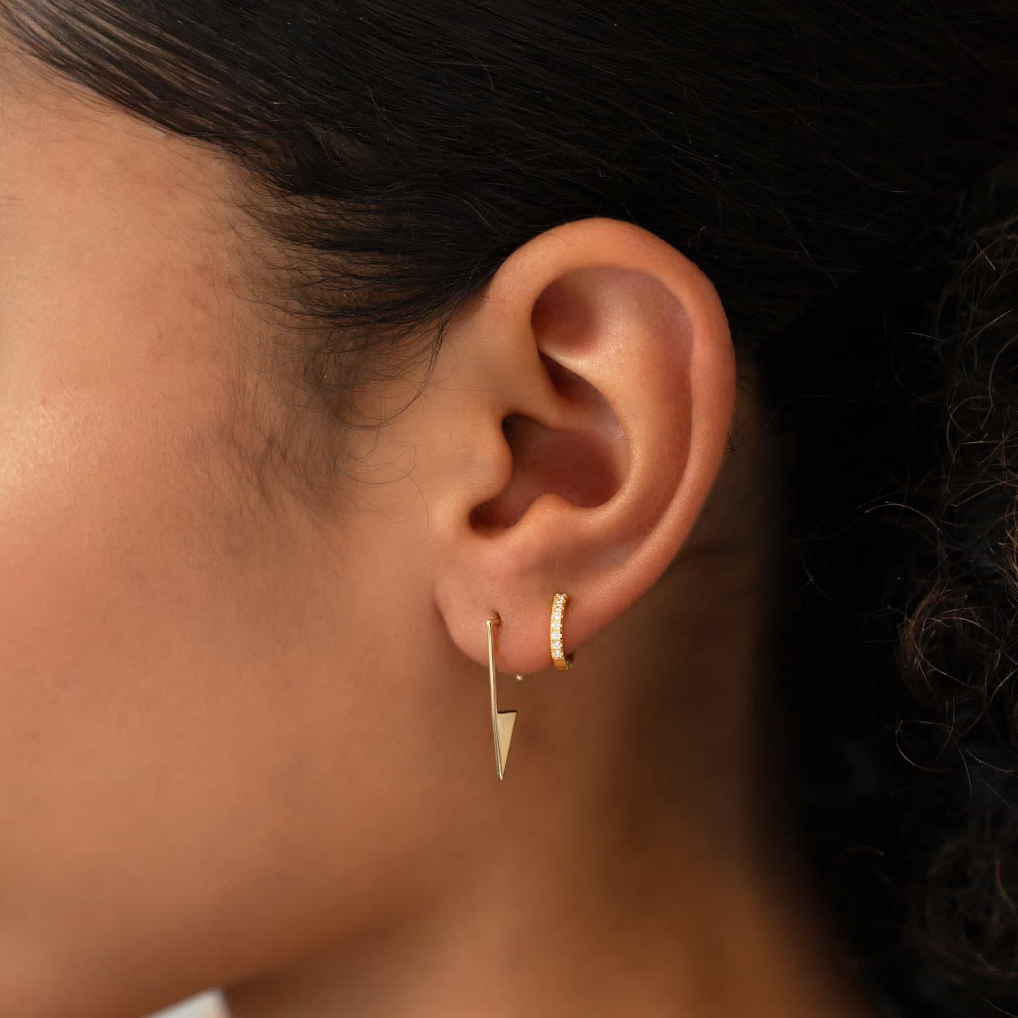 14K gold triangle threader earring with a pointed drop, shown on a model's lobe with a hoop