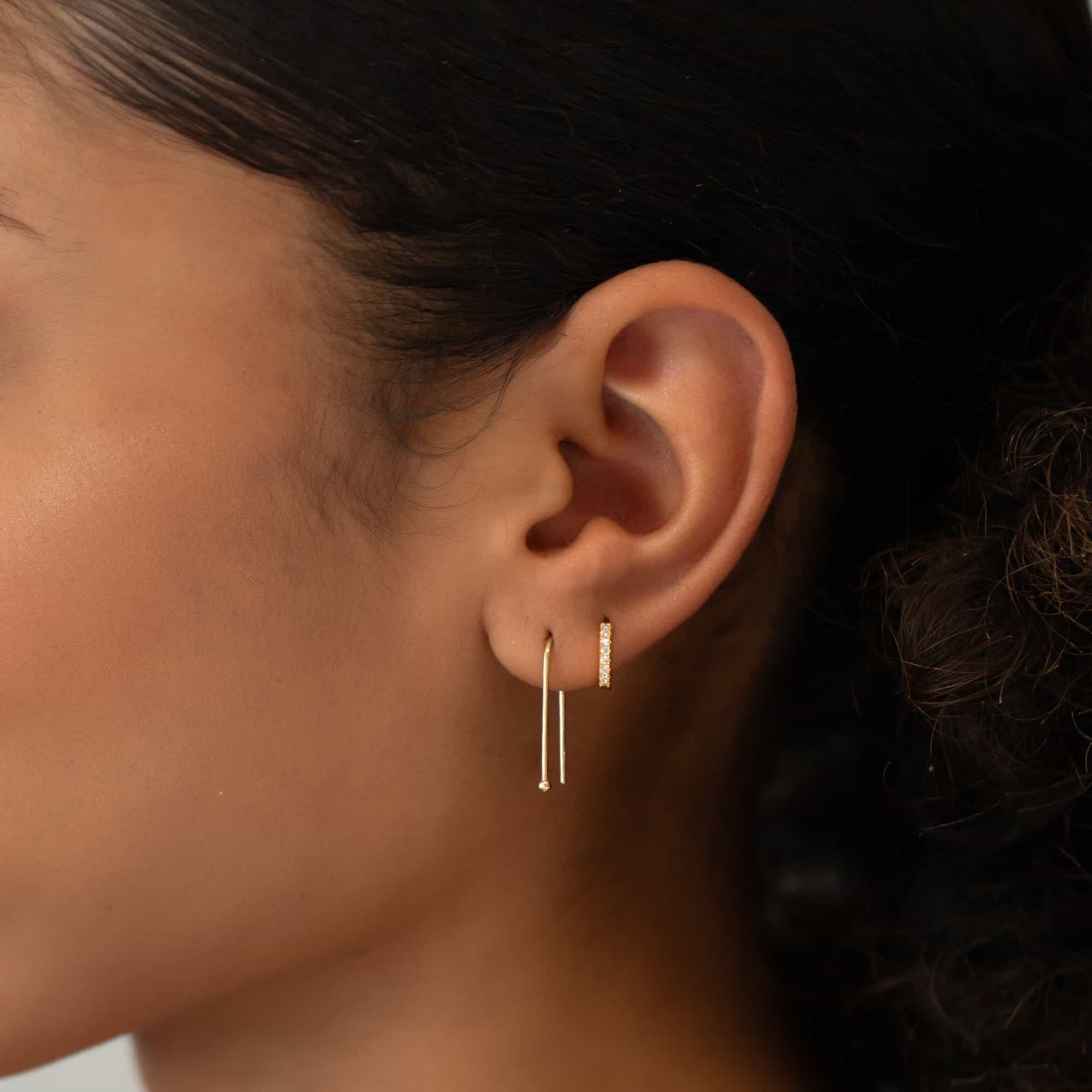 14K gold U-shaped threader earring with a pavé bar huggie, shown on a model's lobe