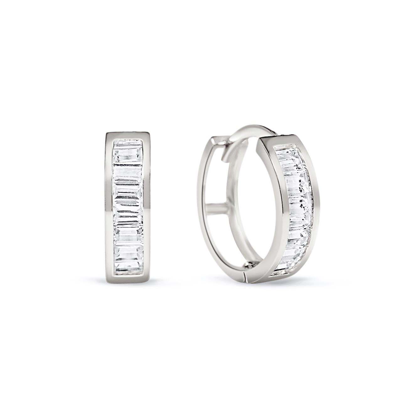 Pair of 14K white gold huggie hoops with channel-set clear baguette stones, on a white background