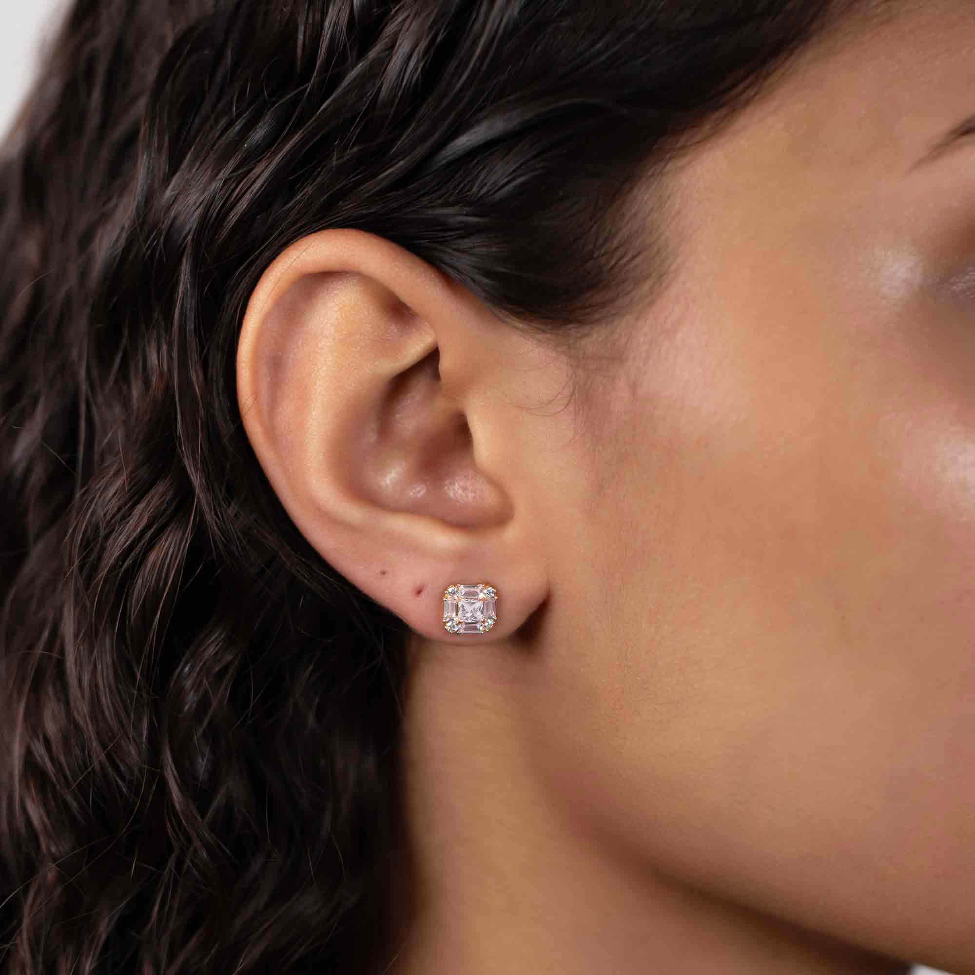 14K gold deco stud with clear white zirconia baguette and round stones, shown on a model's ear