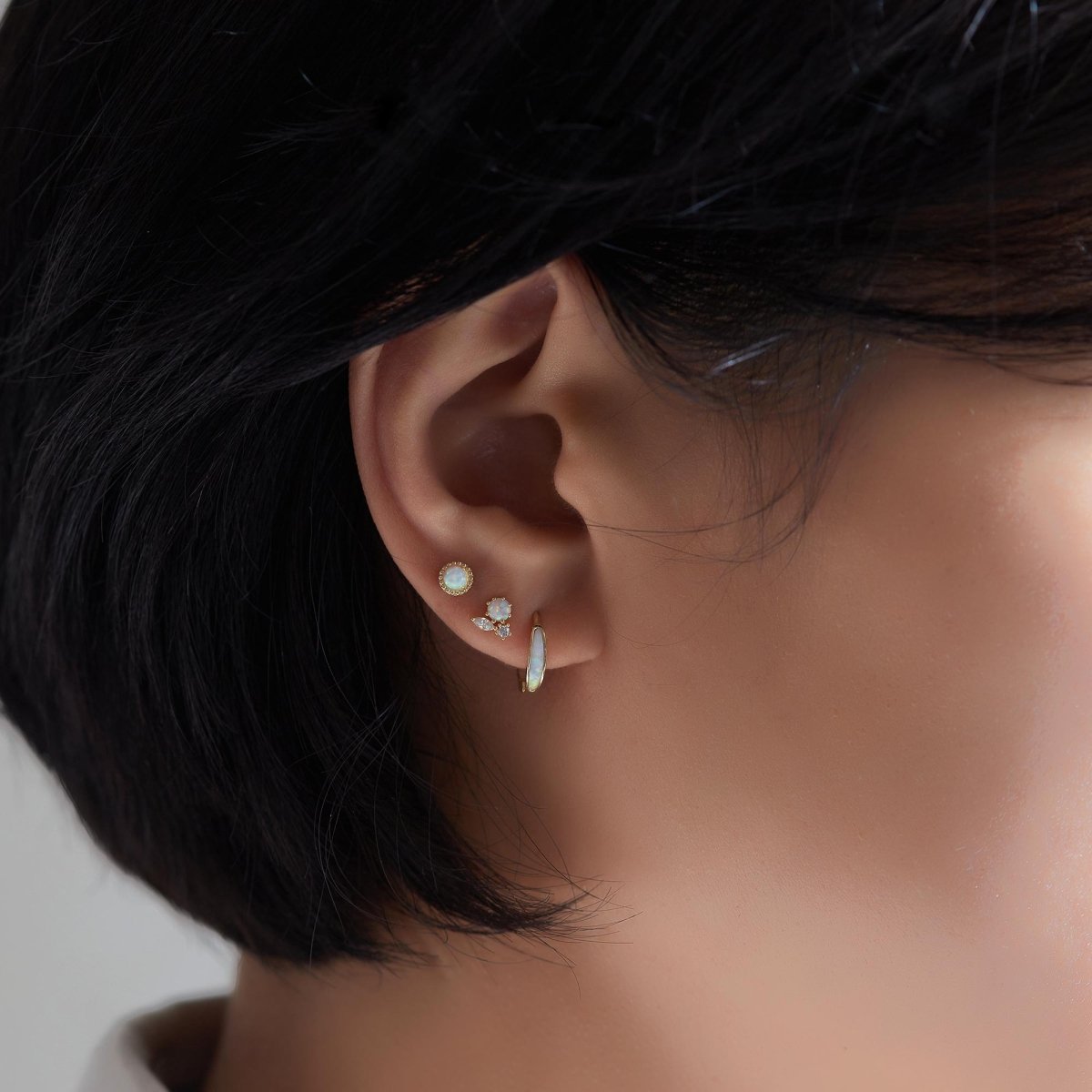 Gold vermeil white opal cluster stud shown on a model's lobe in an ear stack