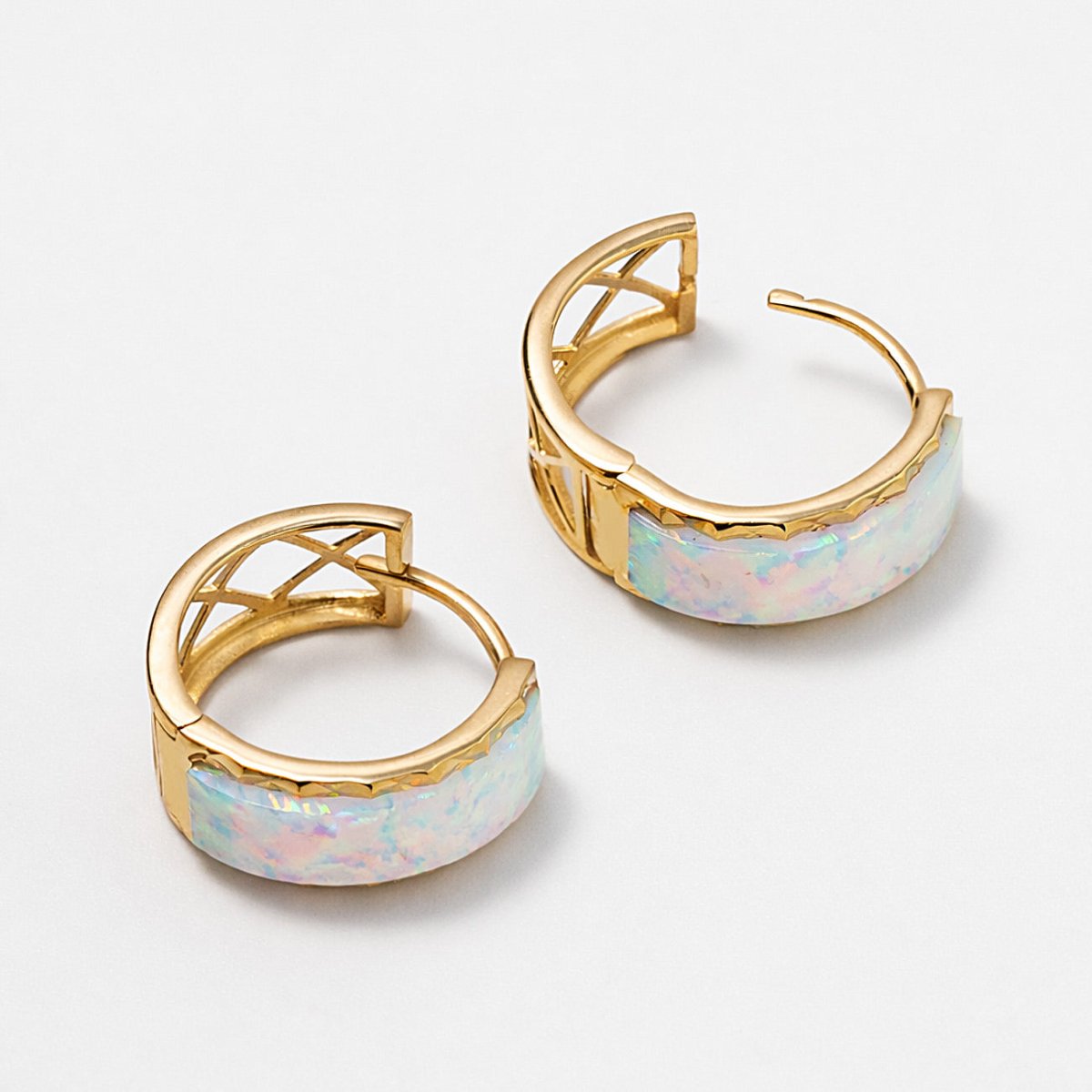 Pair of 14K gold chunky huggie hoops with white opal inlay, shown open on a white background