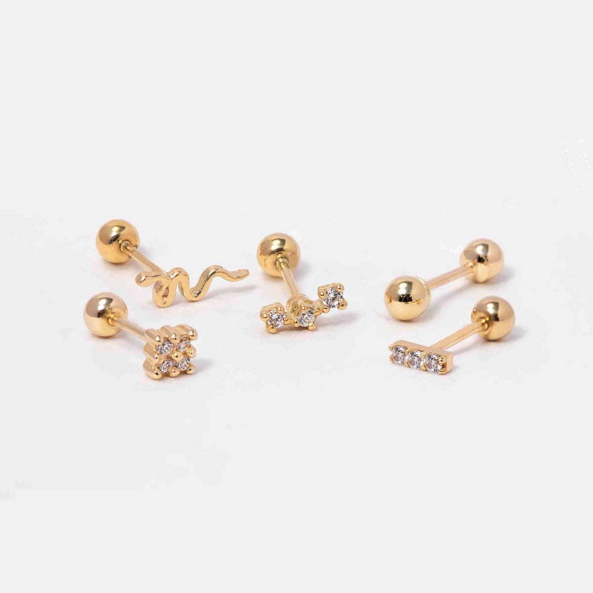 14K gold screw-back stud earrings including a serpent, cluster and clear-stone bar, on a white background