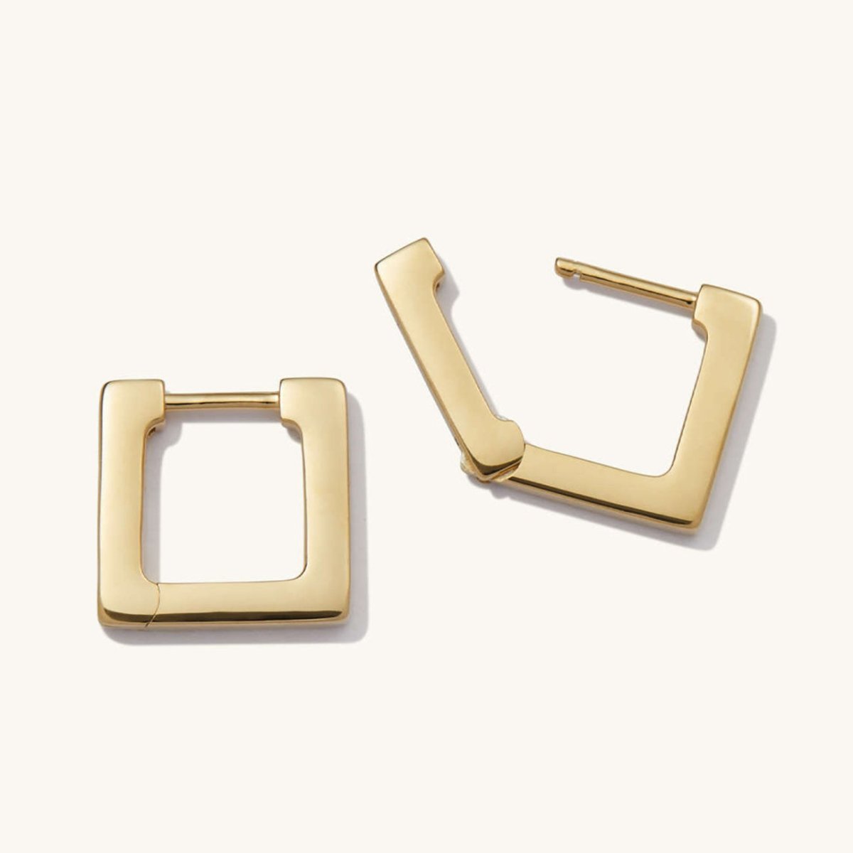 Pair of 14K gold square huggie earrings shown open and closed, on a cream background