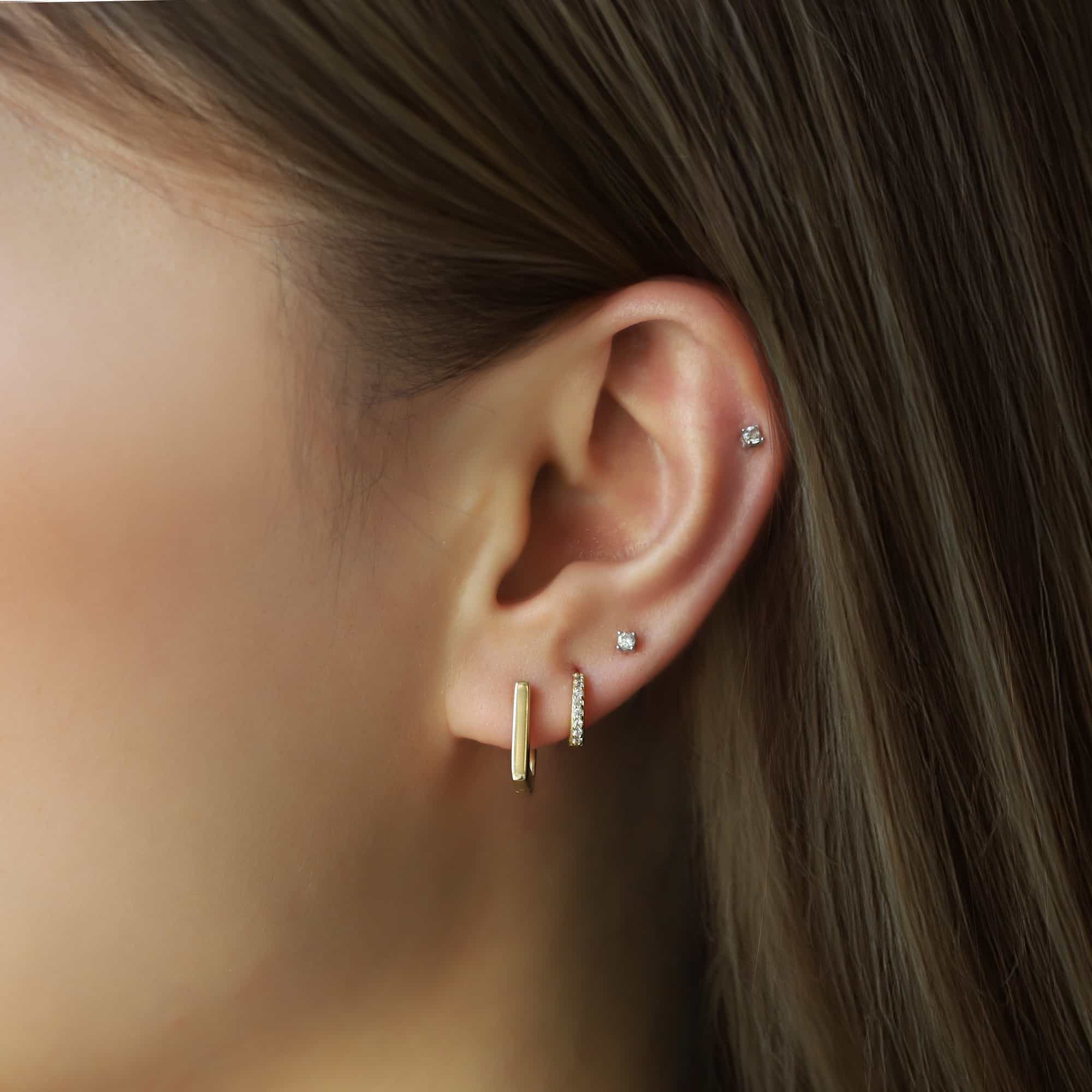14K gold square huggie earring stacked with a pavé huggie, shown on a model's lobe