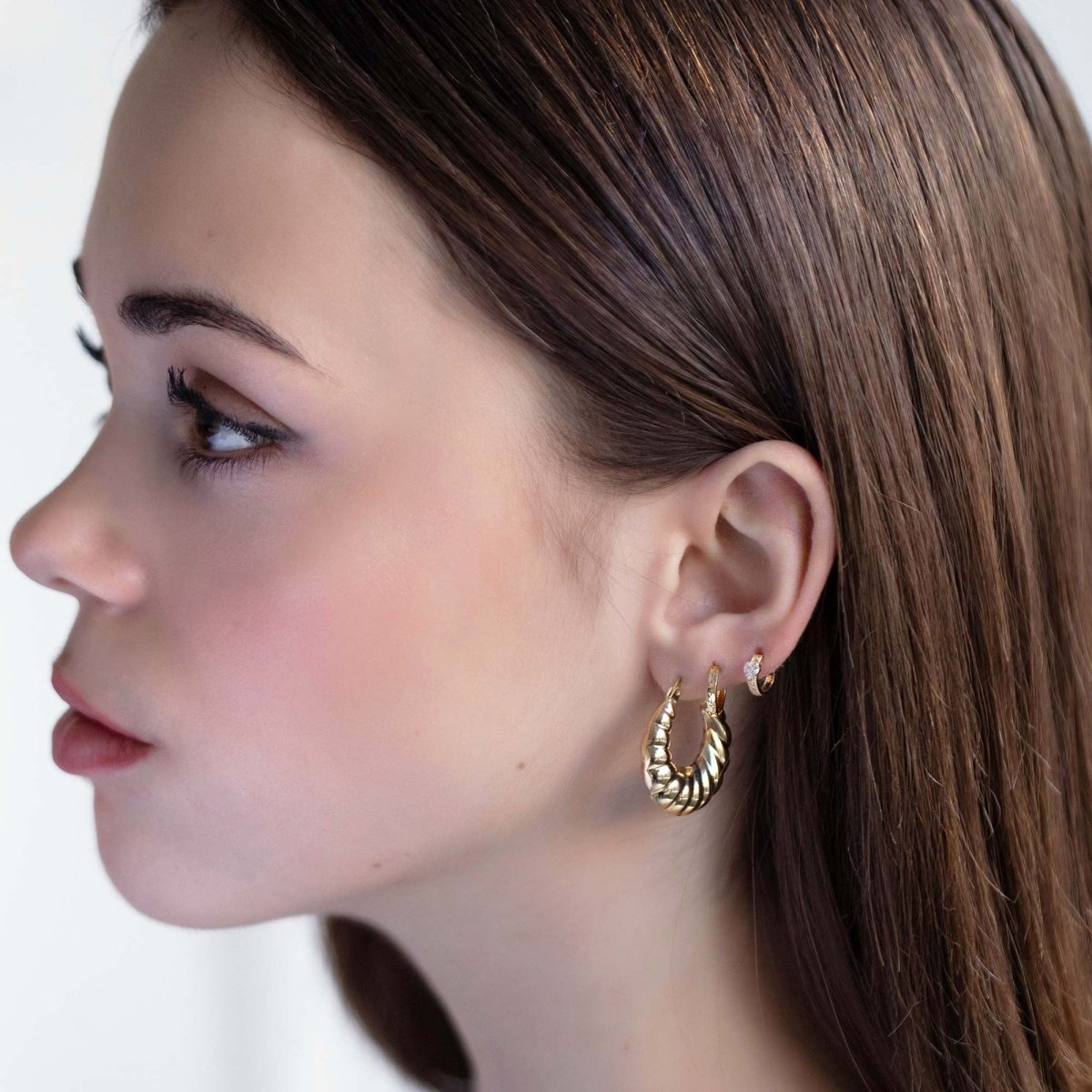 14K gold croissant bubble hoop shown on a model's lobe in profile