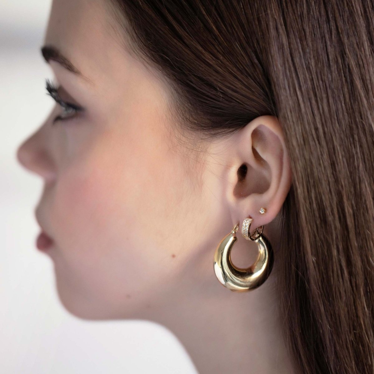 14K gold puffy bubble hoop earring with a pavé huggie, shown on a model's ear