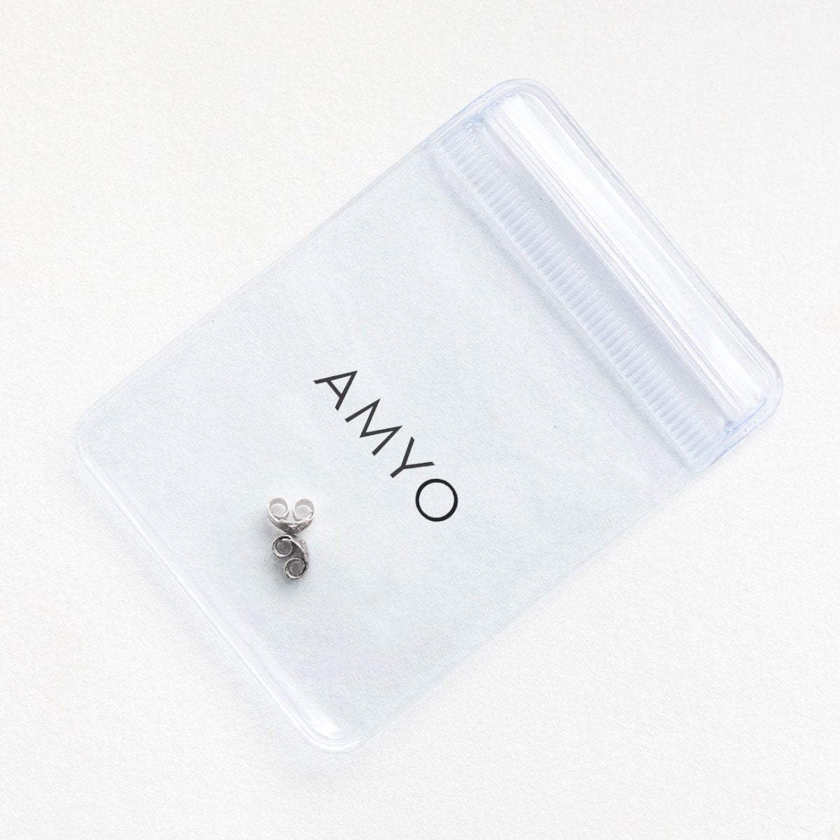 14K white gold earring backs on a frosted AMYO pouch, close-up of friction butterfly backs