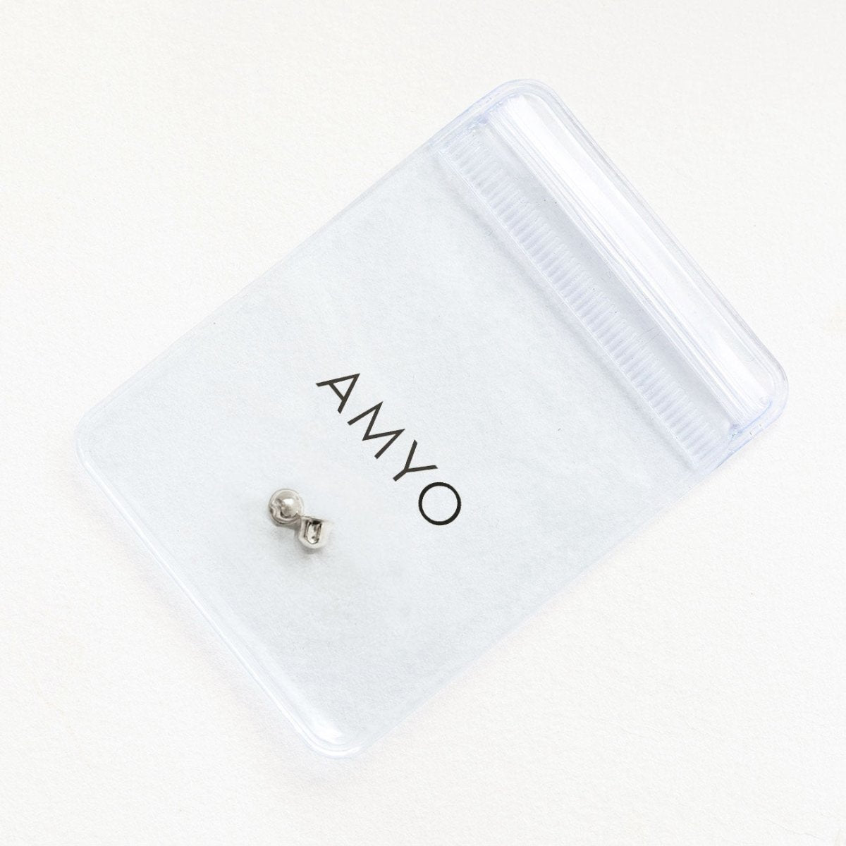 14K white gold screw-back earring back in a branded pouch, on a cream background