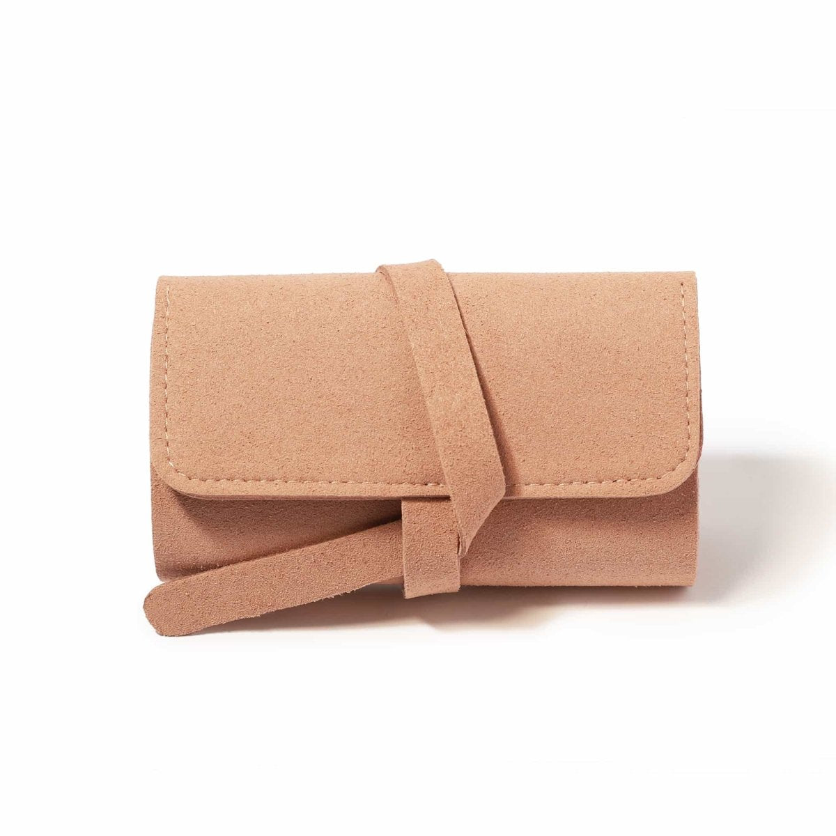 Pink suede travel jewelry roll closed with a wraparound tie, on a white background