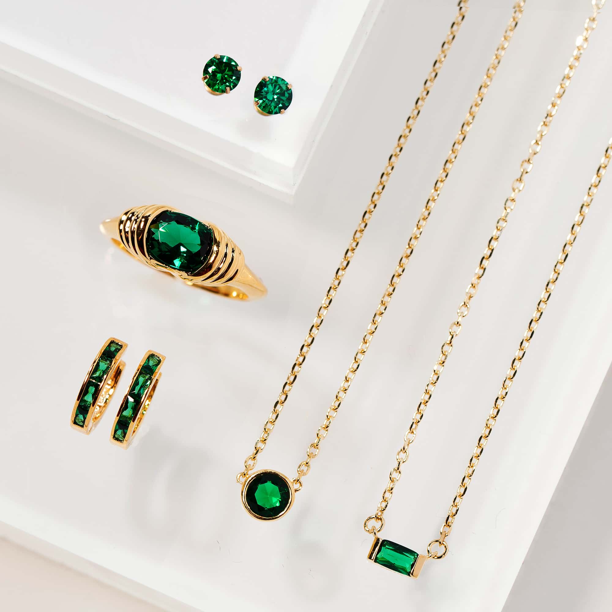 Gold vermeil ring with a green stone shown with matching green-stone studs, hoops and necklaces