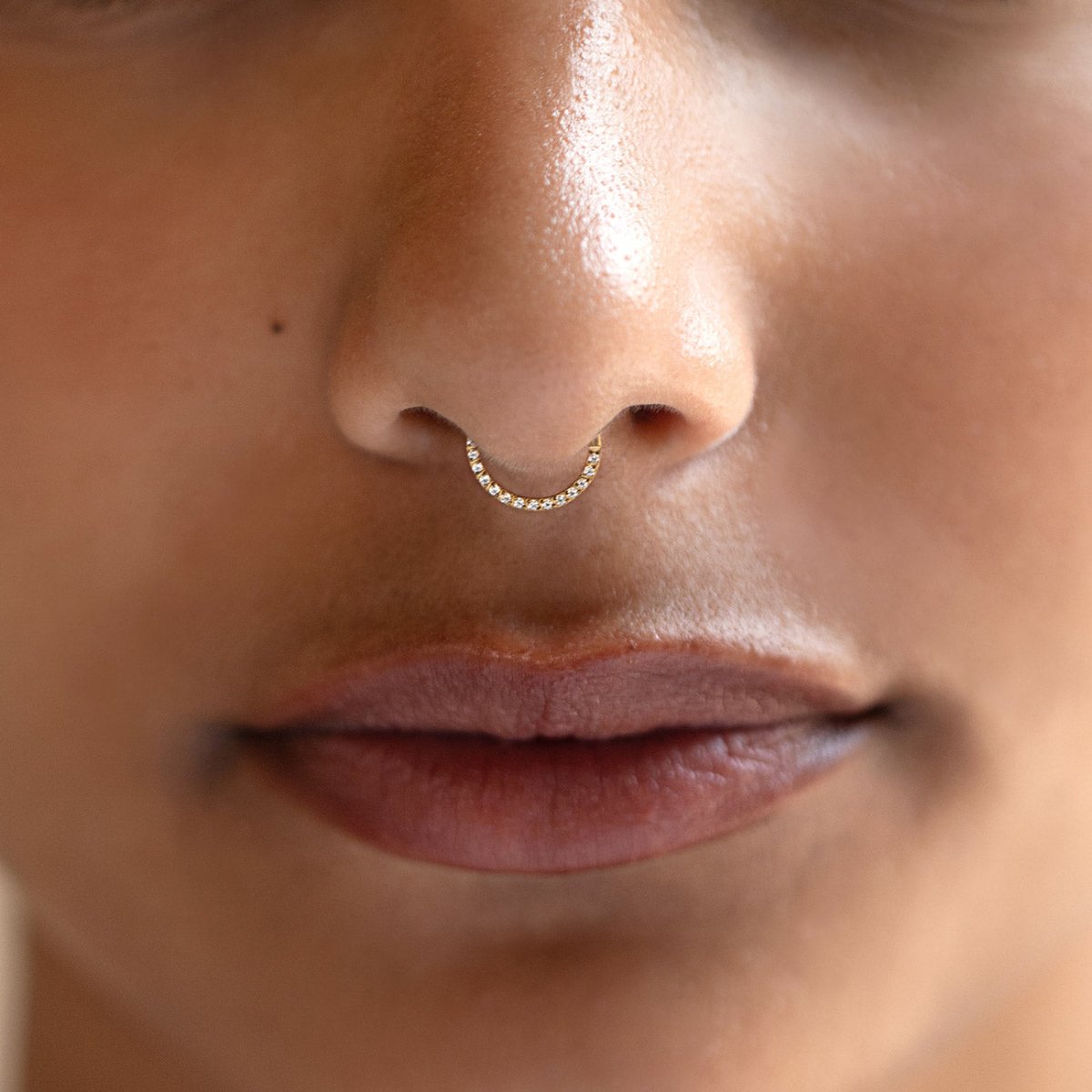 Gold Titanium seamless nose hoop with front pavé crystals, shown in a close-up on a model.