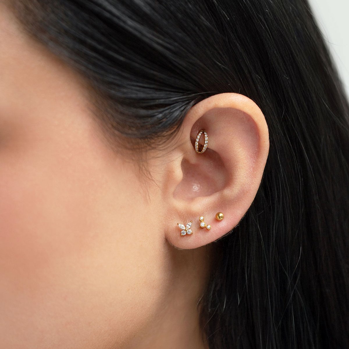 Gold pavé ear cuff and a tiny sphere flat back stud shown on a model's ear