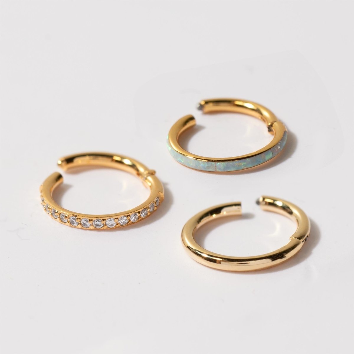 Close-up of gold vermeil seamless clicker ring and gold stainless steel cartilage pave hoop earring