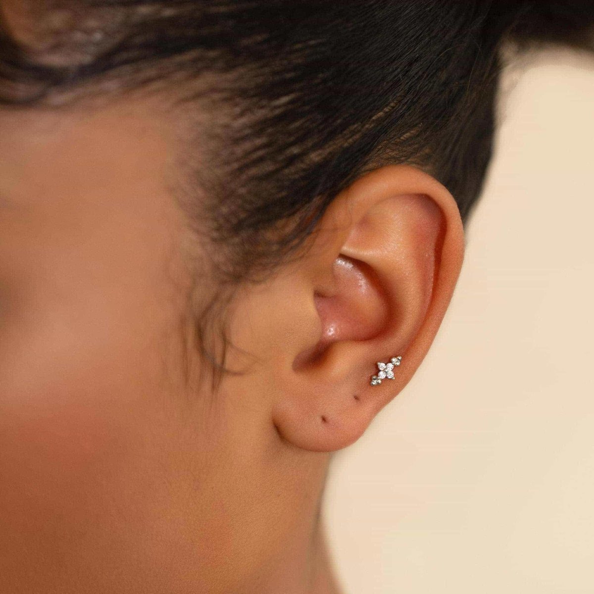 Sterling silver zirconia flower cluster flat back stud shown on a model's upper ear cartilage