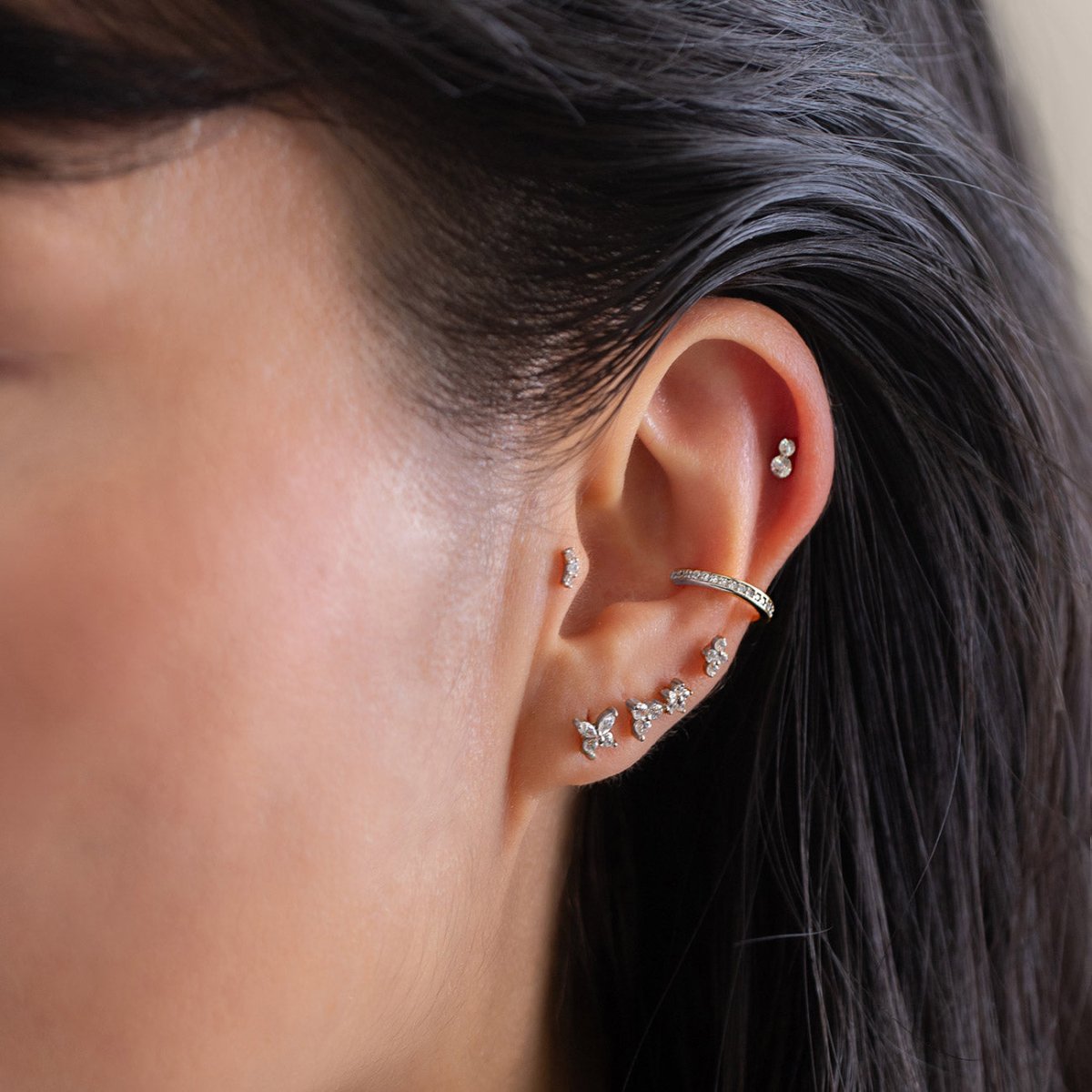 As worn photo of model wearing titanium earrings on four lower piercings, ear cuff, helix and tragus piercing |#Gemstone_White Zirconia