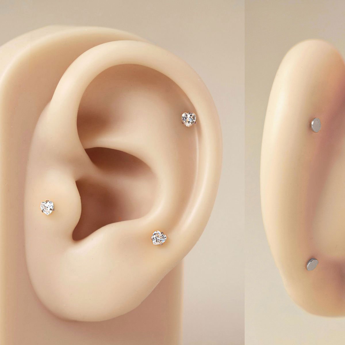 Titanium heart flat back studs with clear stones shown on a silicone ear model, two views