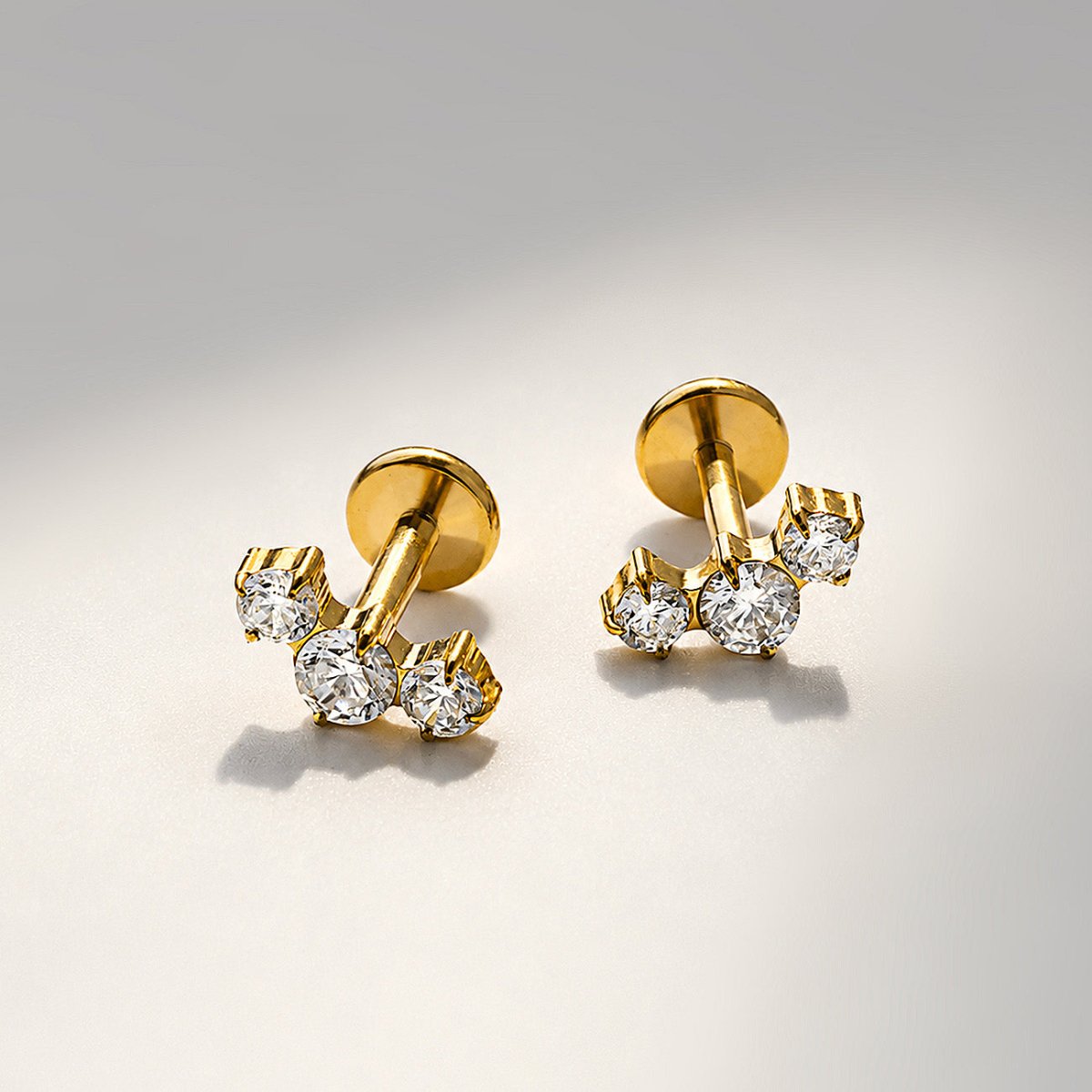 Gold titanium tres curve pavé flat back stud earrings, close-up detail