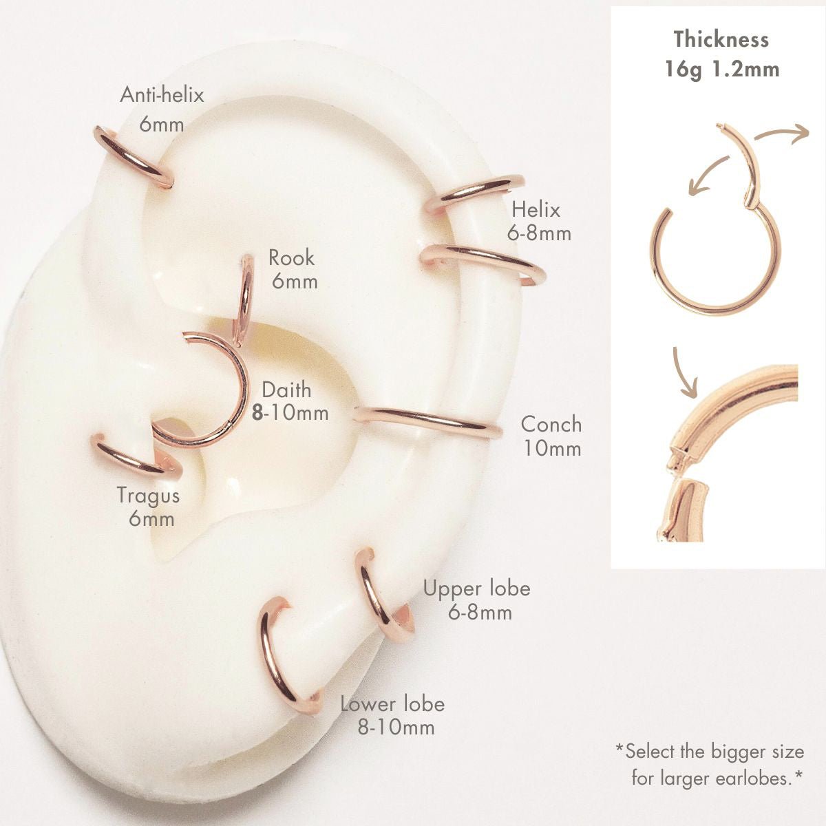 14K rose gold thin hoop with a clear dangling charm, shown on a model's ear