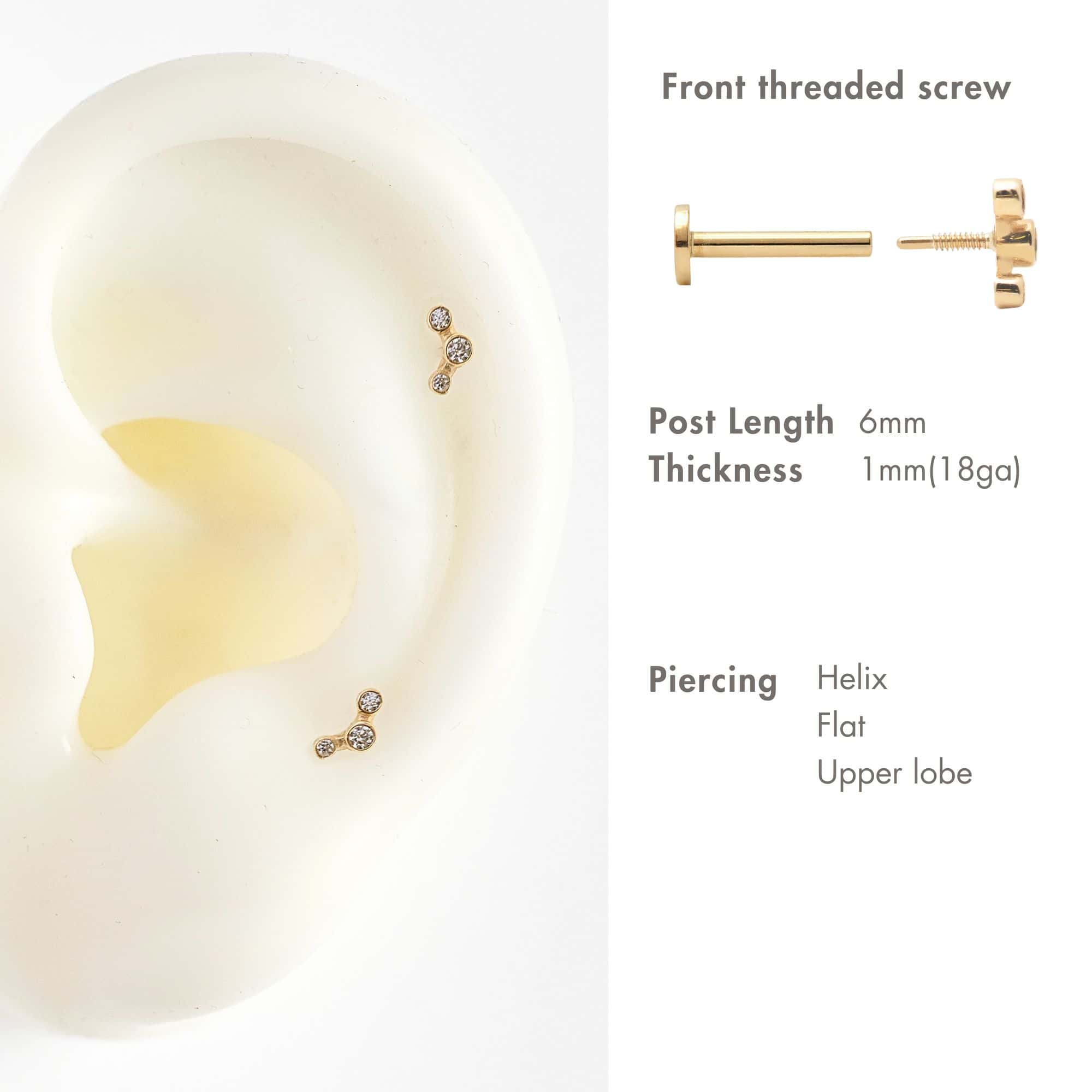 14K gold trio bezel flat back stud with white zirconia, shown on a silicone ear, helix and lobe