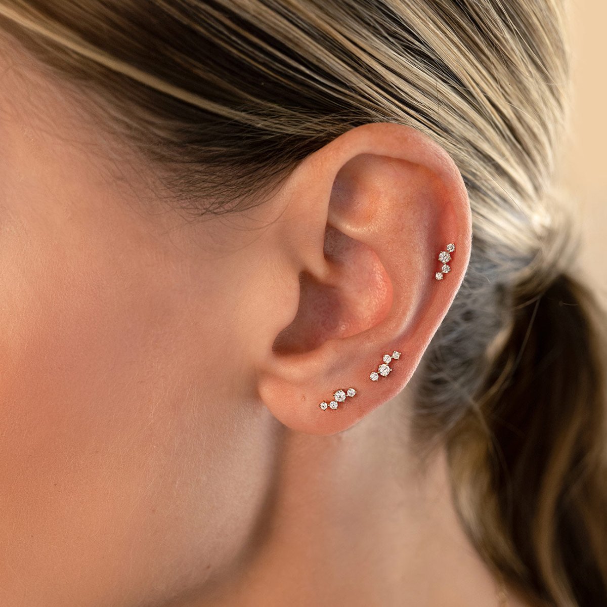 14K gold cluster pavé flat back stud earrings, shown on a model