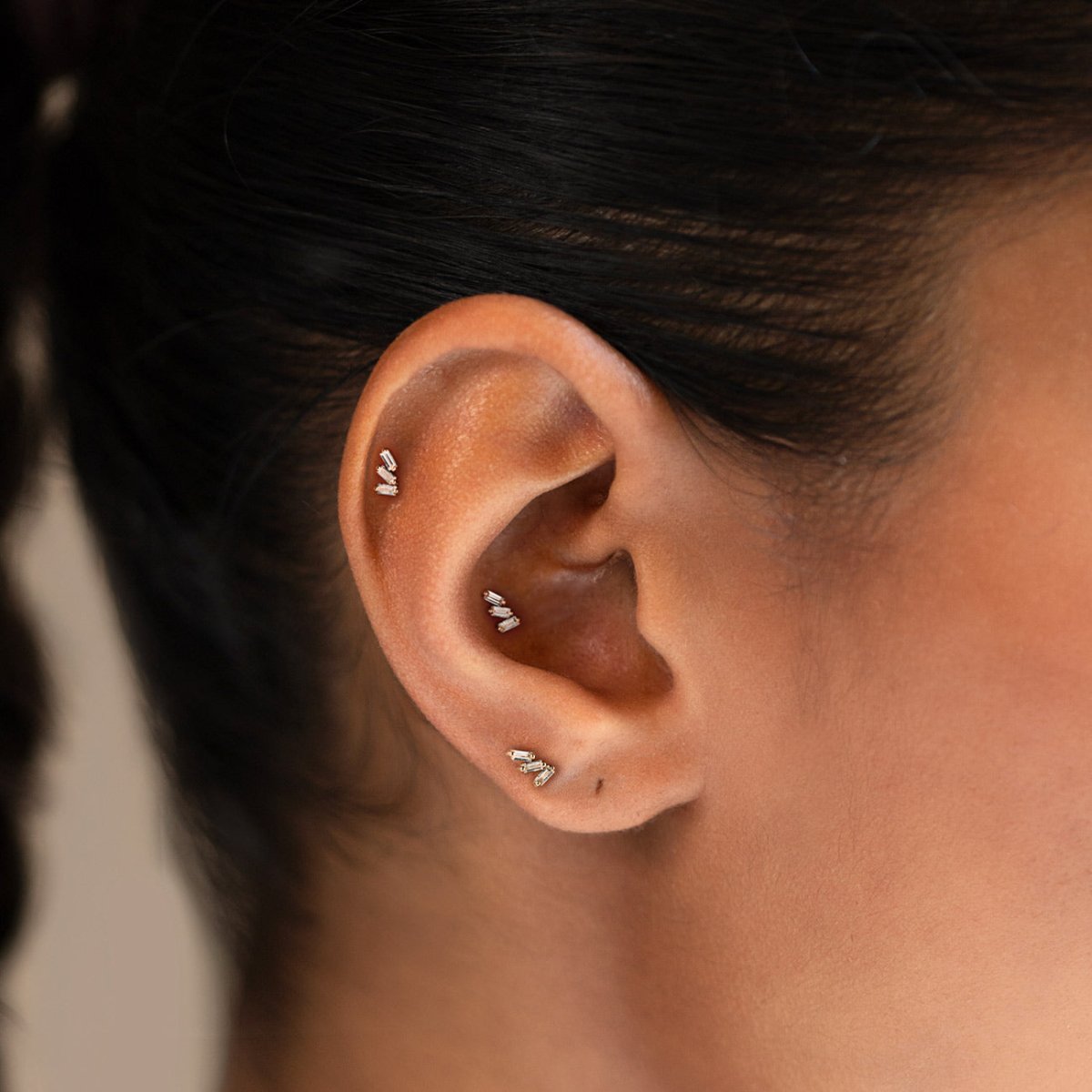 14K gold tri baguette flat back stud earrings, shown on a model