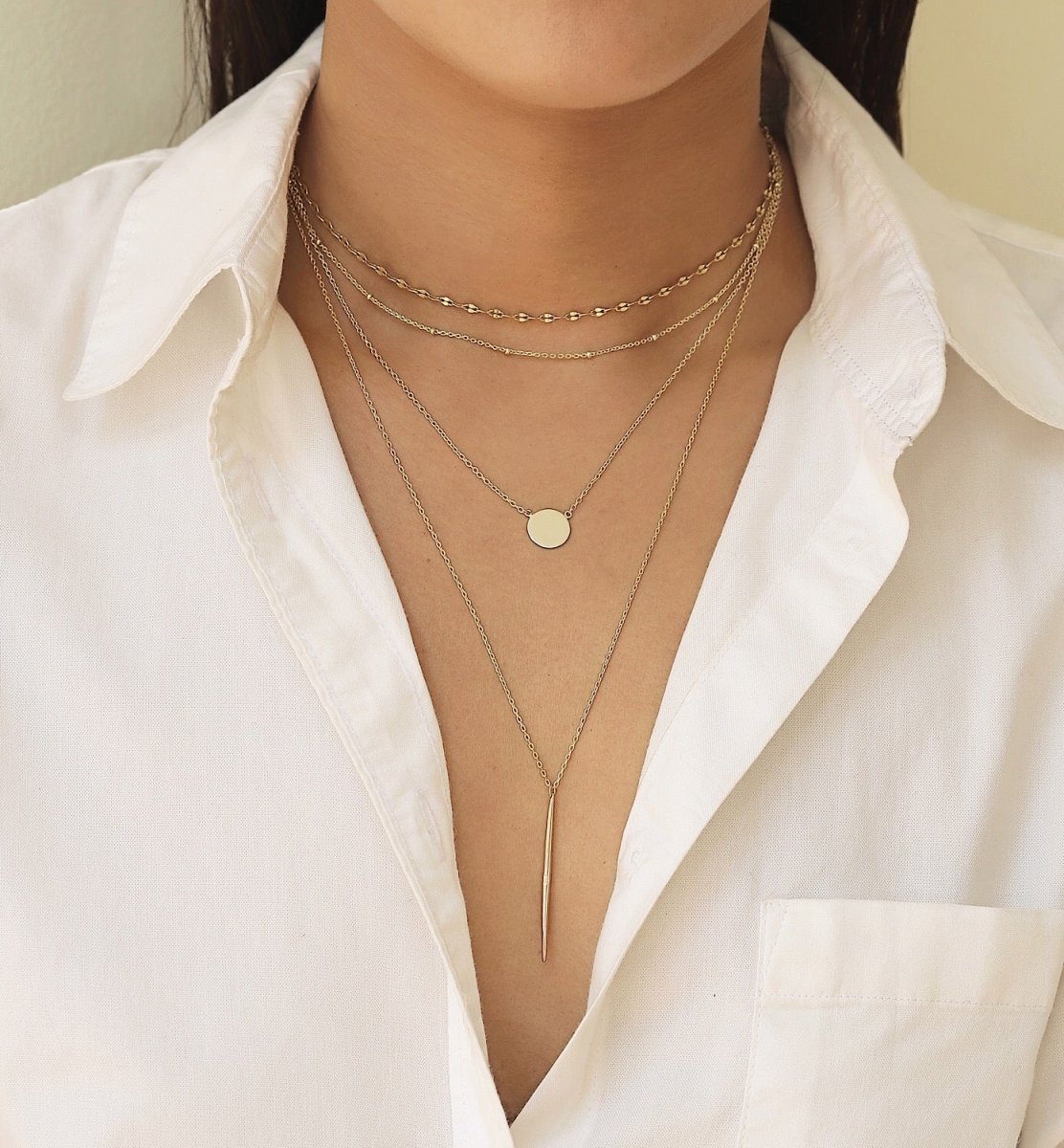 Gold vermeil disc necklace shown layered on a model's neckline with a small round disc pendant