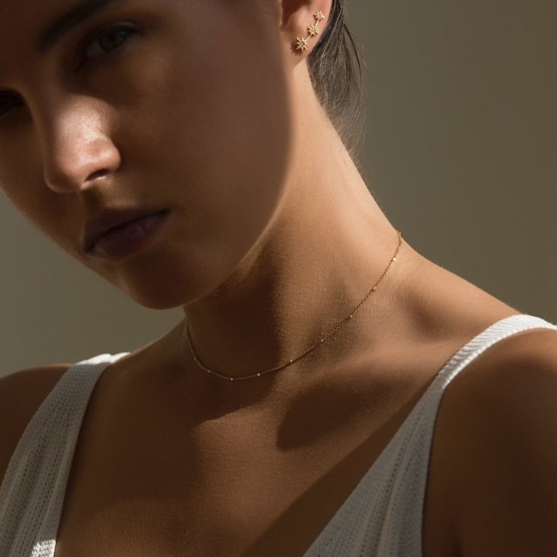 Gold vermeil beaded satellite chain choker, shown on a model's neckline