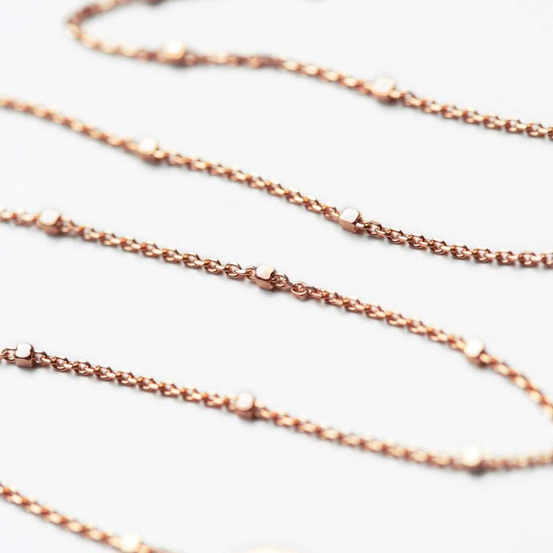 Rose gold vermeil beaded satellite chain chokers, close-up detail on a white background