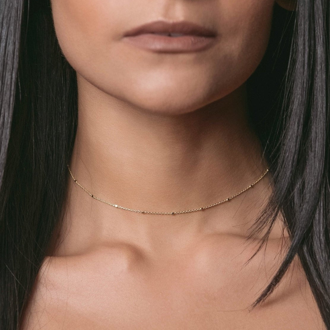 Gold vermeil beaded satellite chain choker, shown on a model's neckline