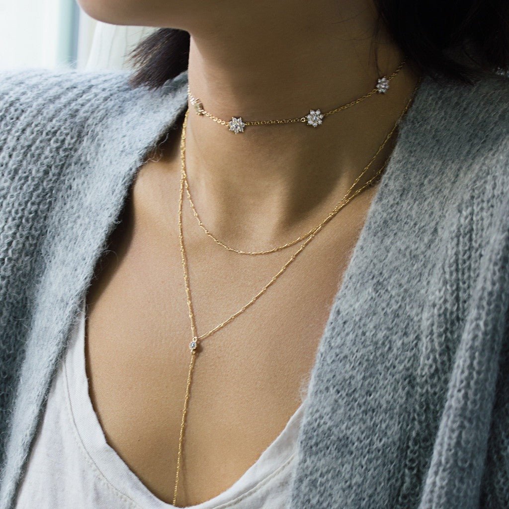 Gold vermeil white zirconia flower choker layered with longer chains, shown on a model