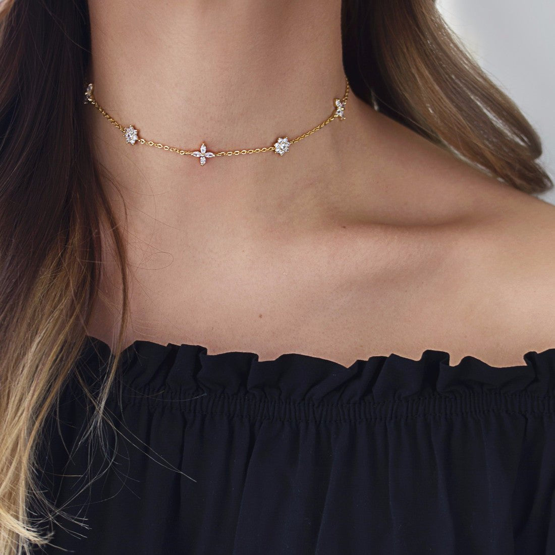 Gold vermeil choker with clear crystal flower clusters, shown on a model's neckline