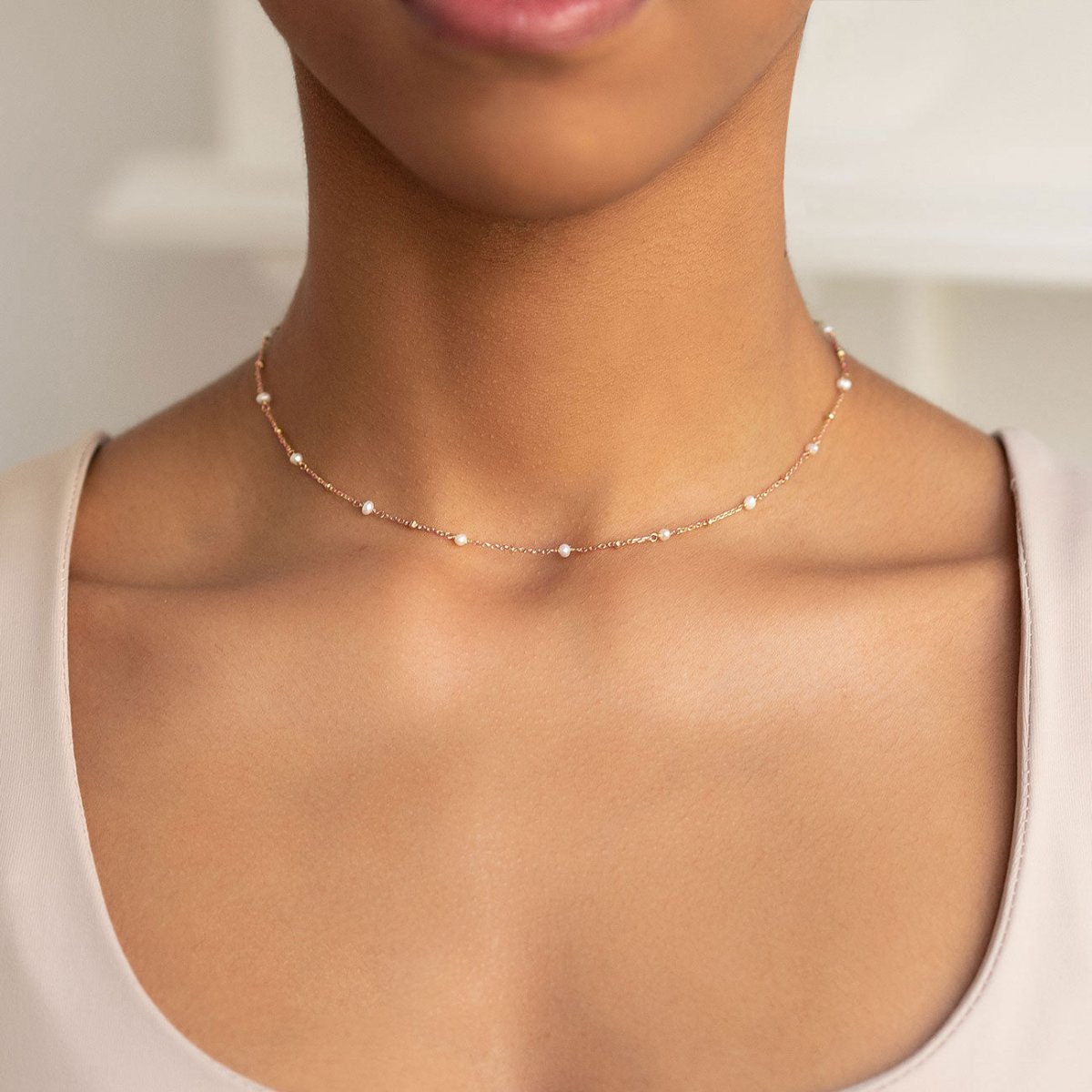 Rose gold vermeil pearl choker necklace shown on a model's neckline
