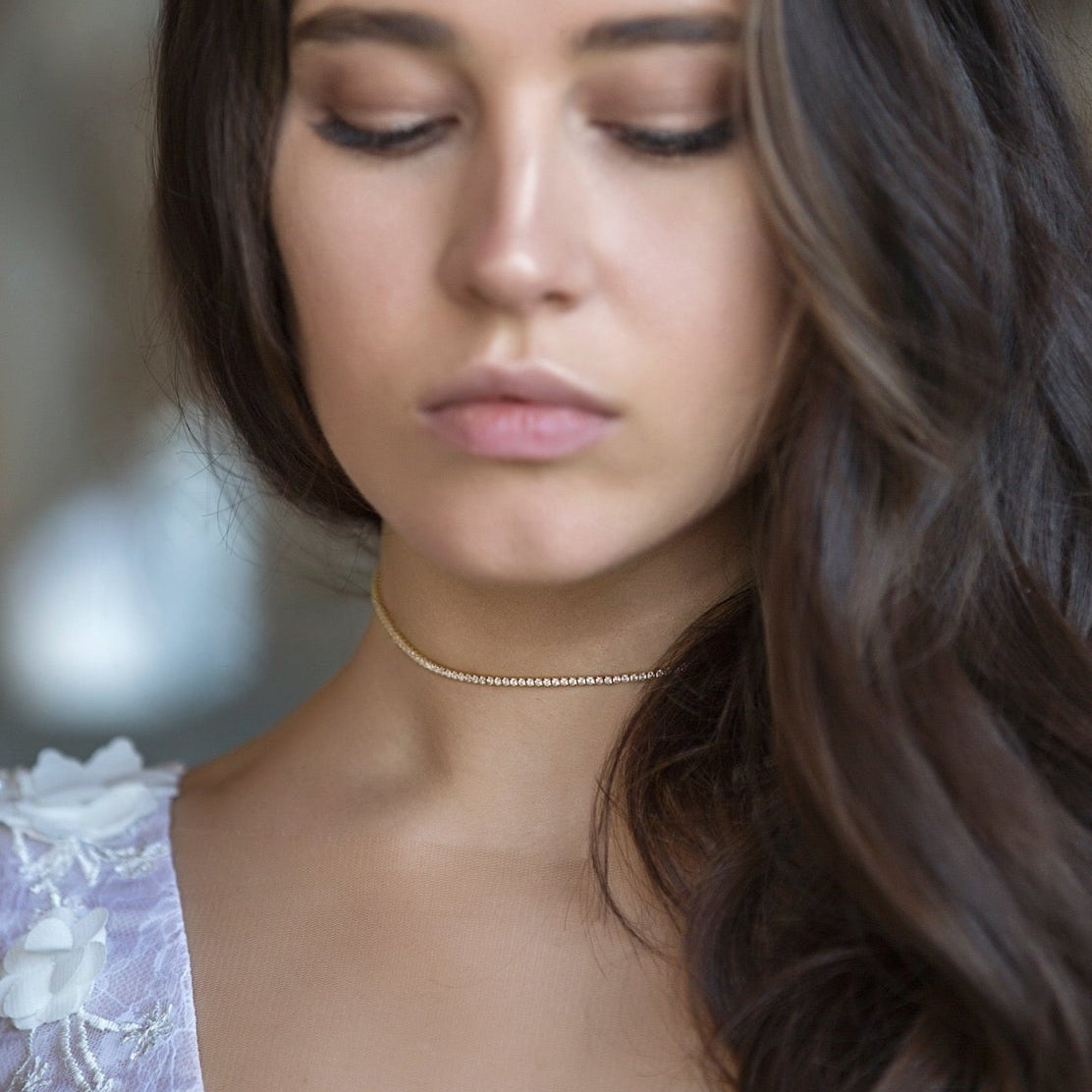 Gold vermeil crystal choker with round clear stones, shown close at a model's neckline