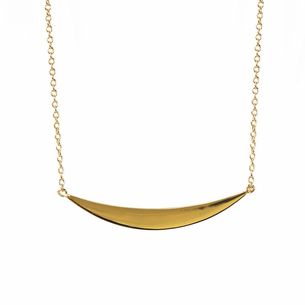 Gold vermeil curved crescent bar pendant on a delicate chain, close-up detail on a white background