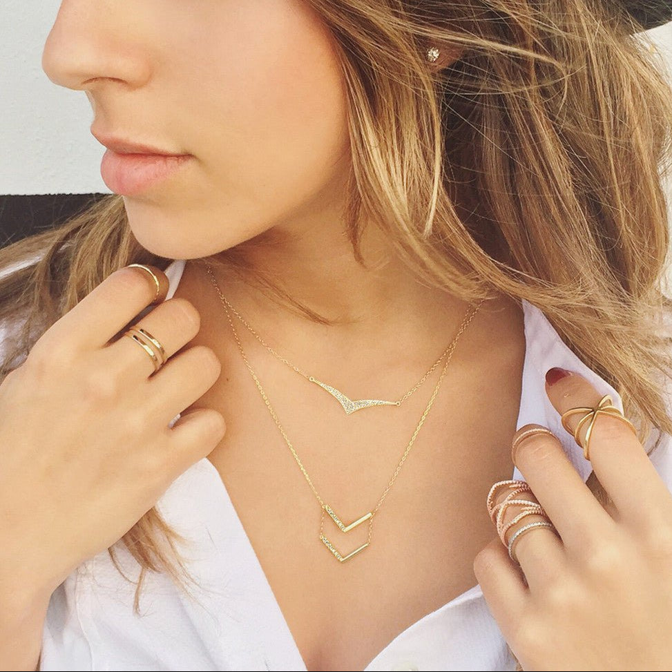Gold vermeil pave chevron necklace shown layered on a model's neckline