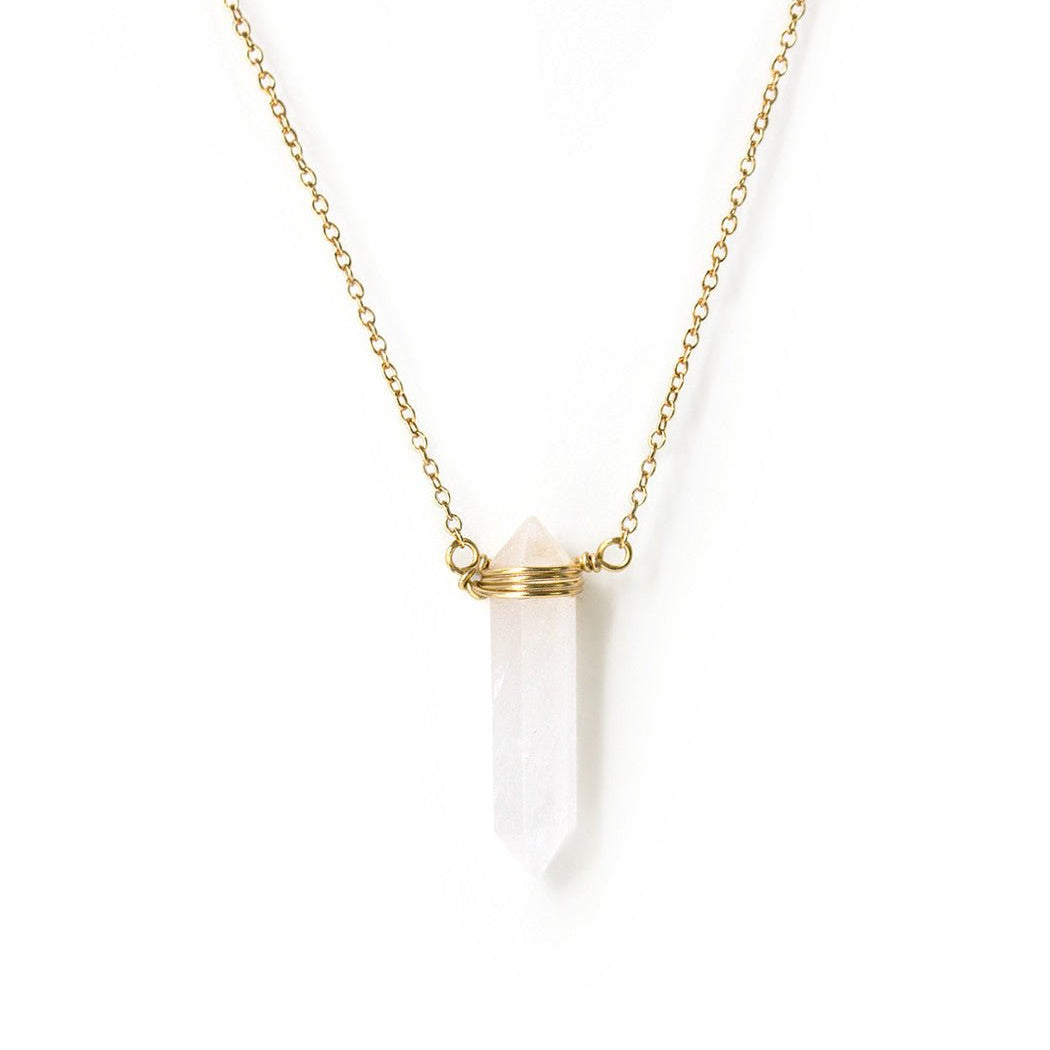 Gold vermeil necklace with a pointed clear quartz pendant, on a white background