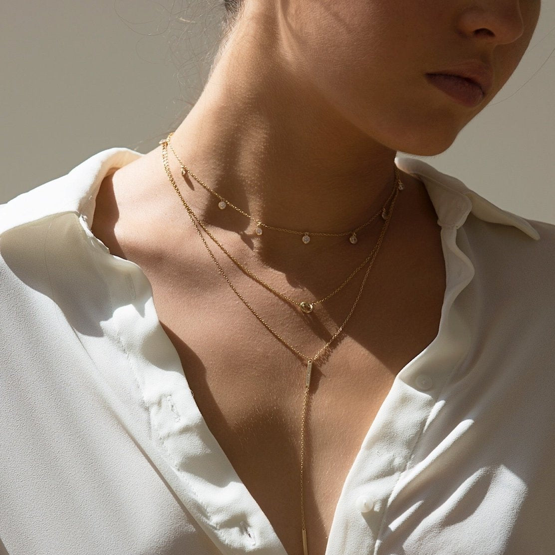 Gold vermeil dangle choker with small clear stones, shown layered on a model's neckline