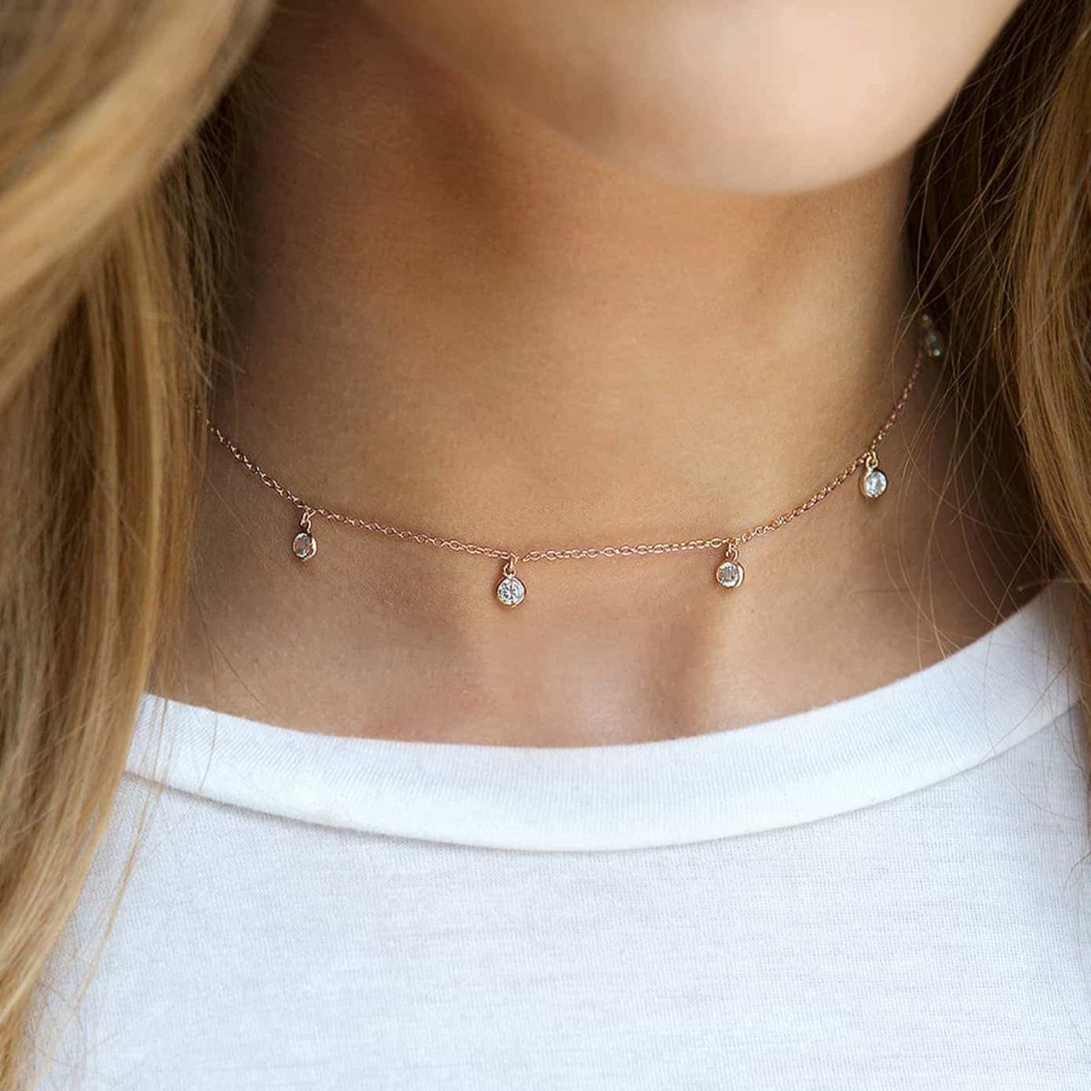 Rose gold vermeil choker with four dangling clear stones, shown on a model's neckline