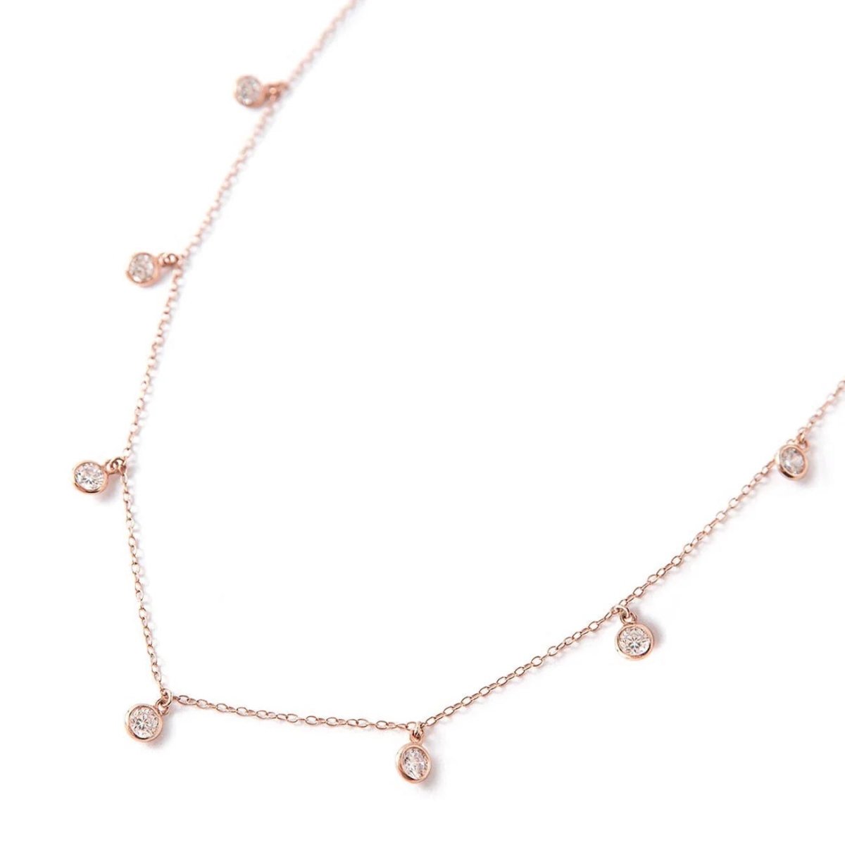 Rose gold vermeil choker chain with dangling clear bezel stones, laid on a white background