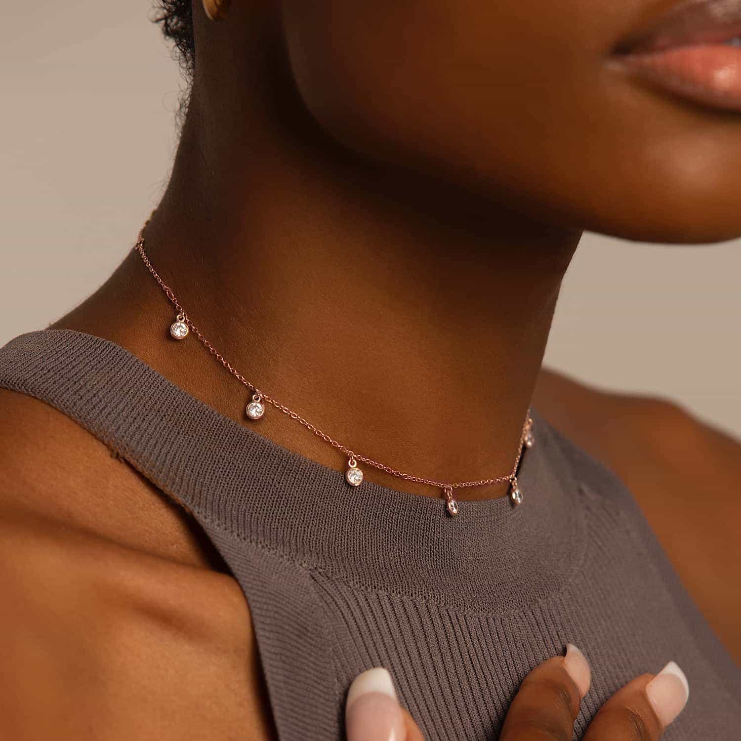 Rose gold vermeil choker with dangling clear stones, shown on a model's neckline