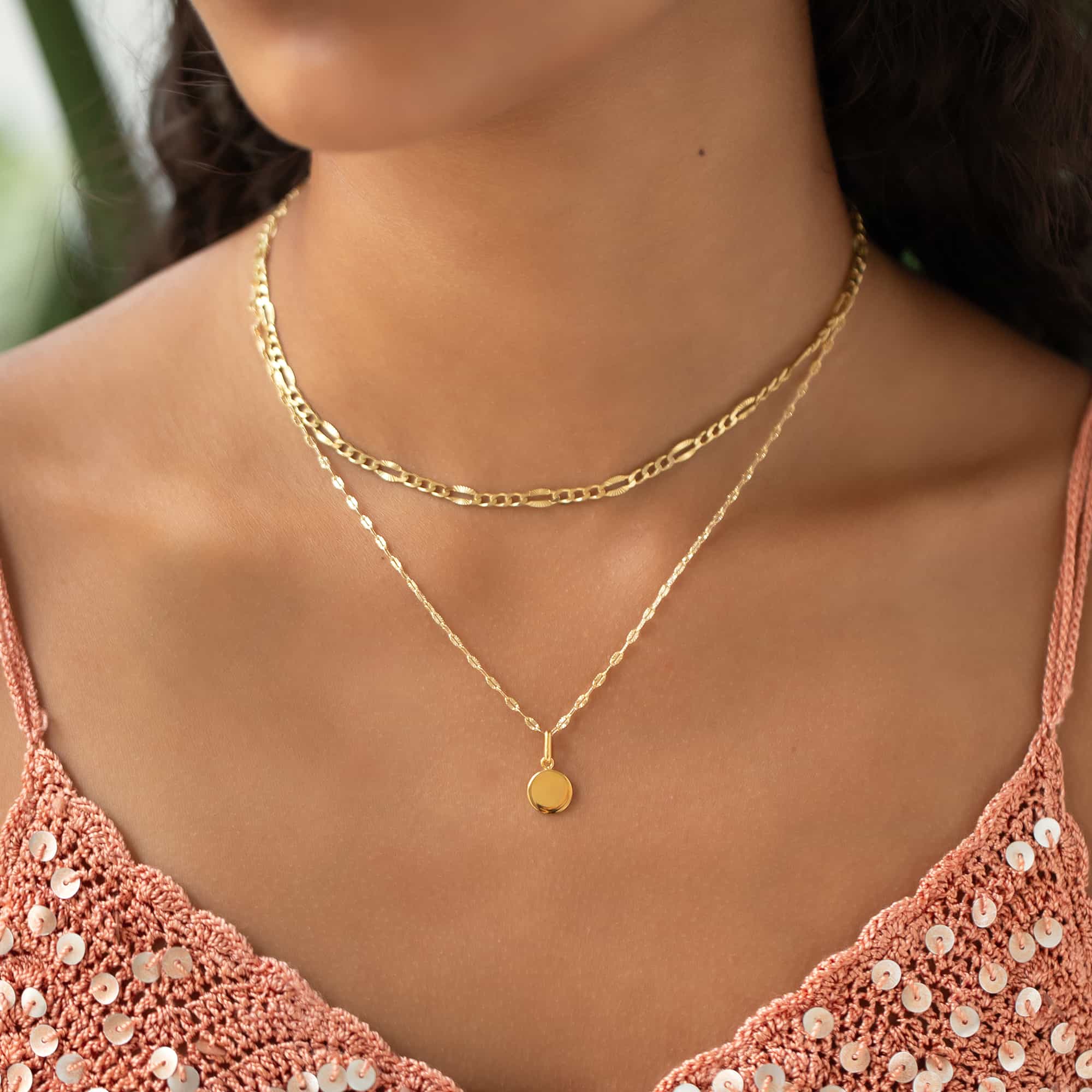Gold vermeil round disc pendant on a thin chain, shown layered on a model's neckline