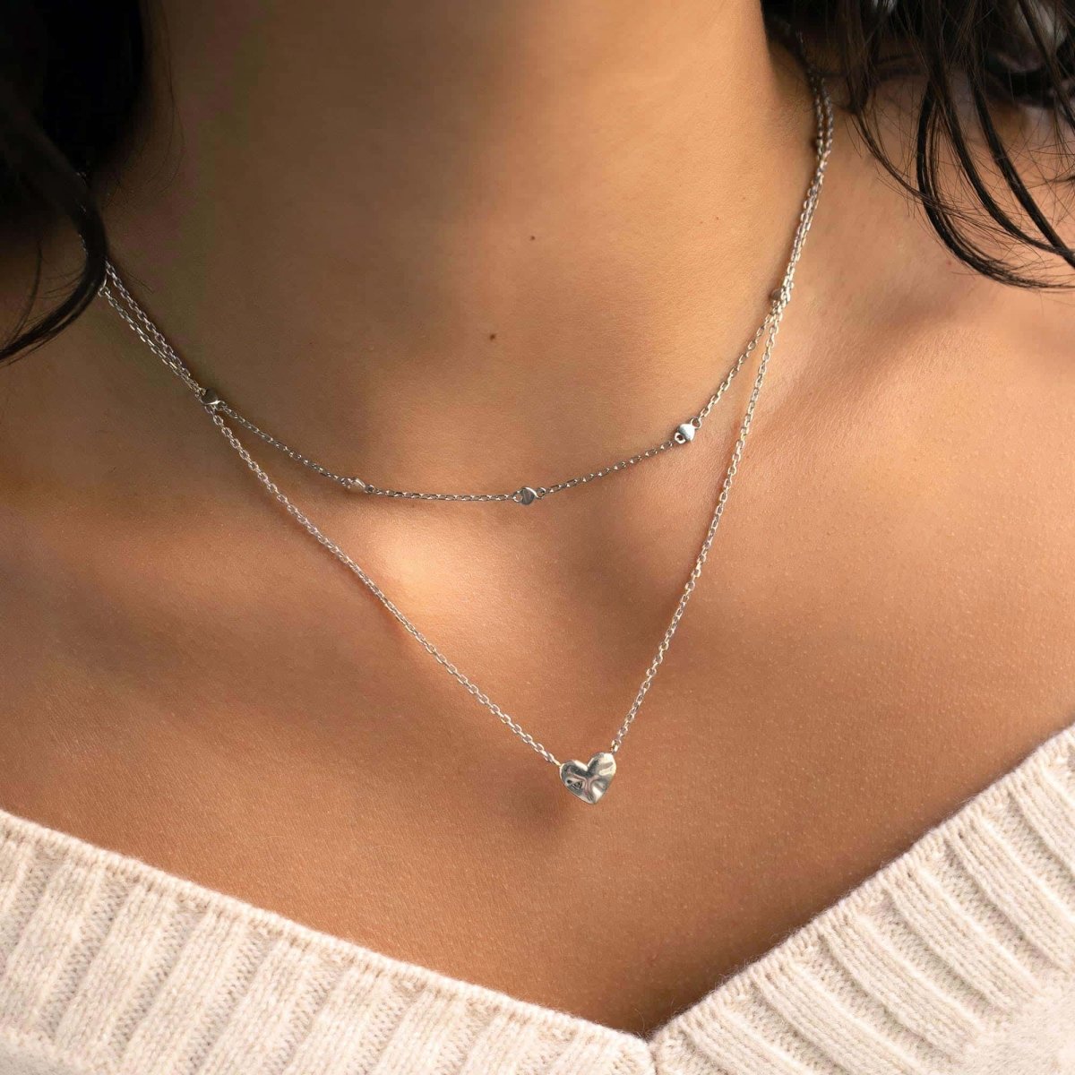 Sterling silver puffed heart pendant necklace, shown layered on a model's neckline