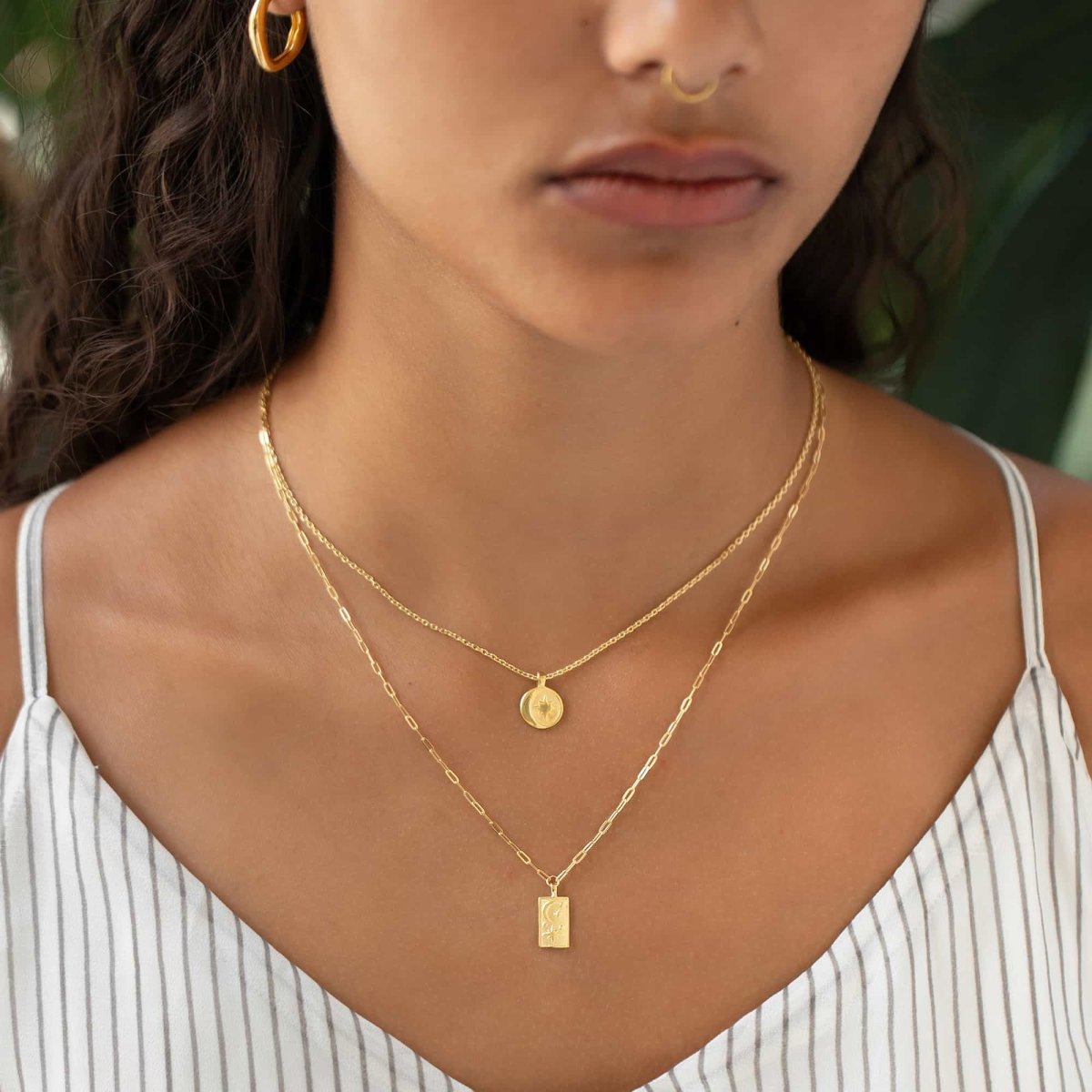 Gold vermeil moon-and-star coin pendant layered on a chain, shown on a model's neckline