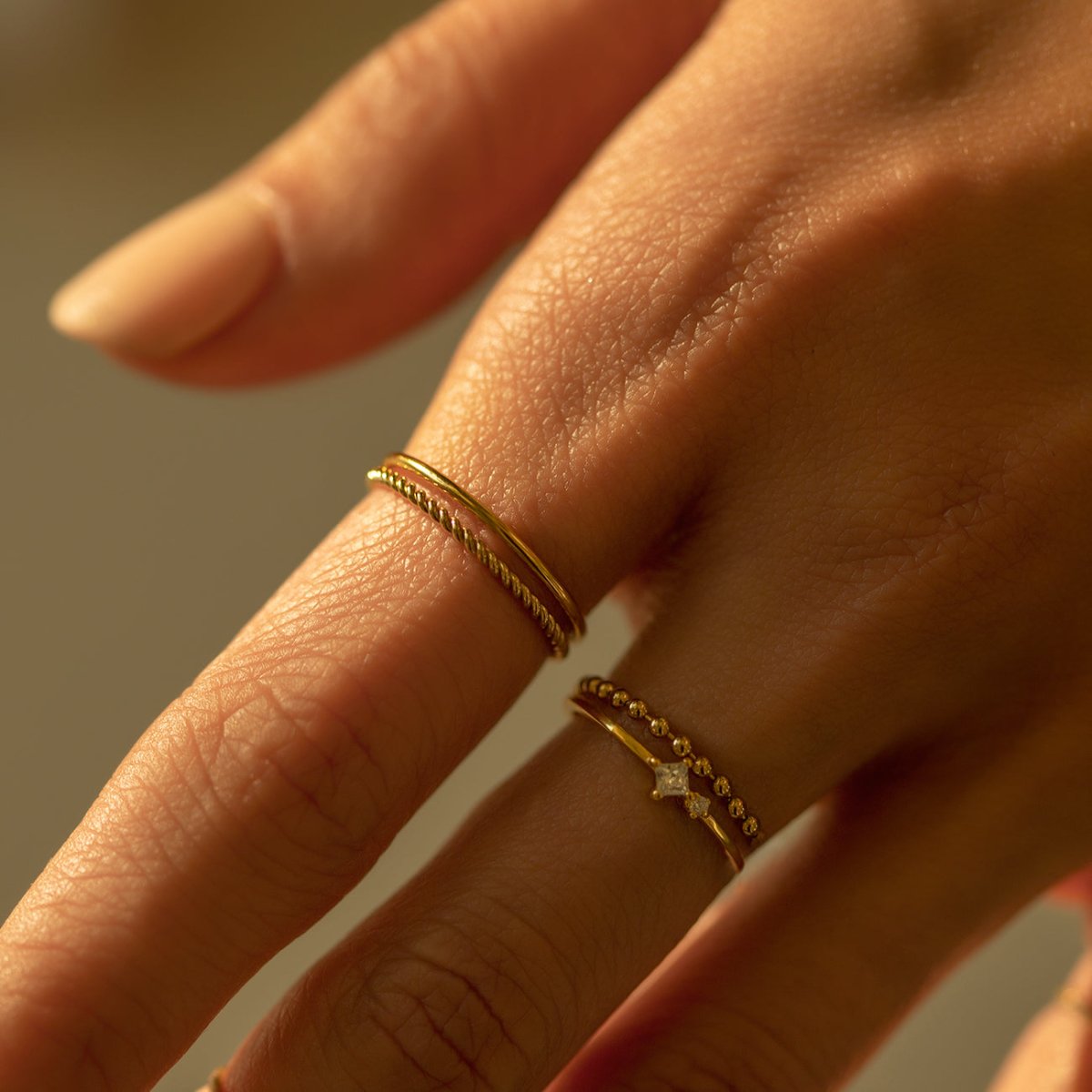 Gold-filled thin band and rope ring set, close-up of the stacked bands on a model's finger