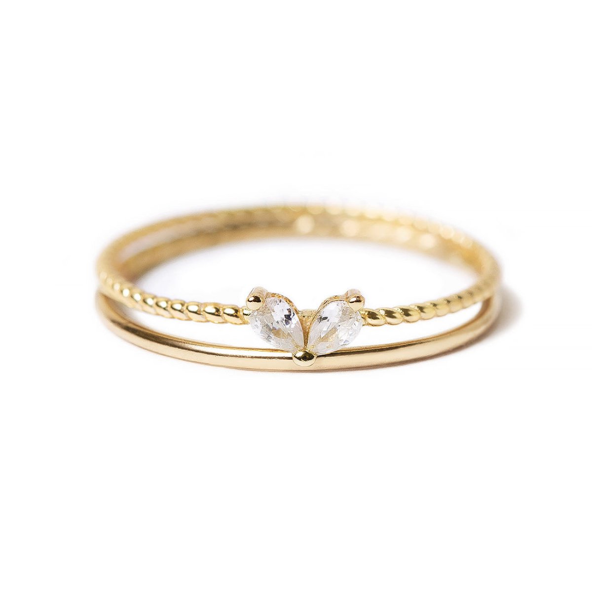 Gold vermeil stacking ring set with twin pear-cut white zirconia stones, on a white background